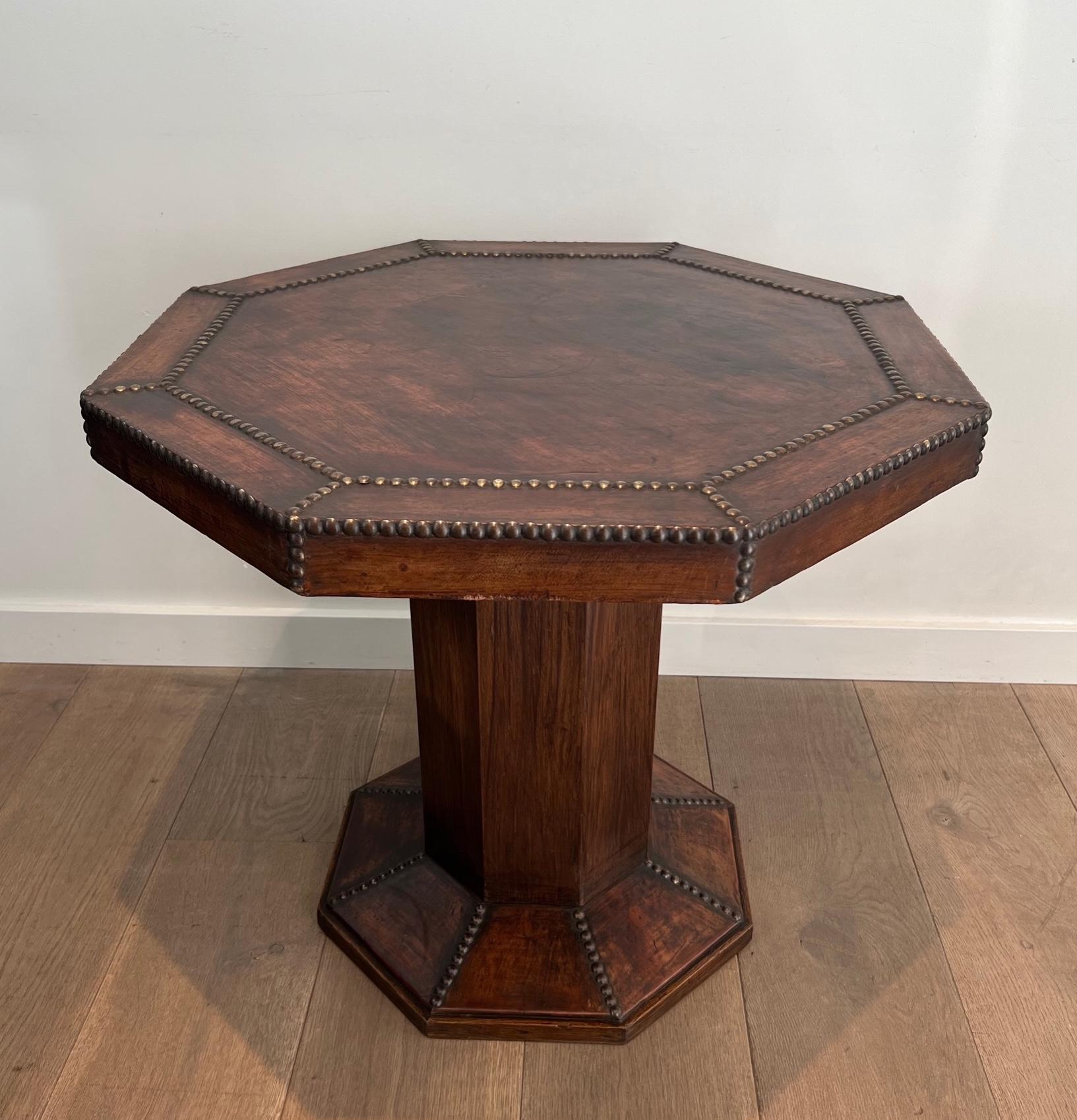This very nice octagonal pedestal table is made of oak and leather, studded with large round-headed brass nails. This is a French work. Circa 1900
