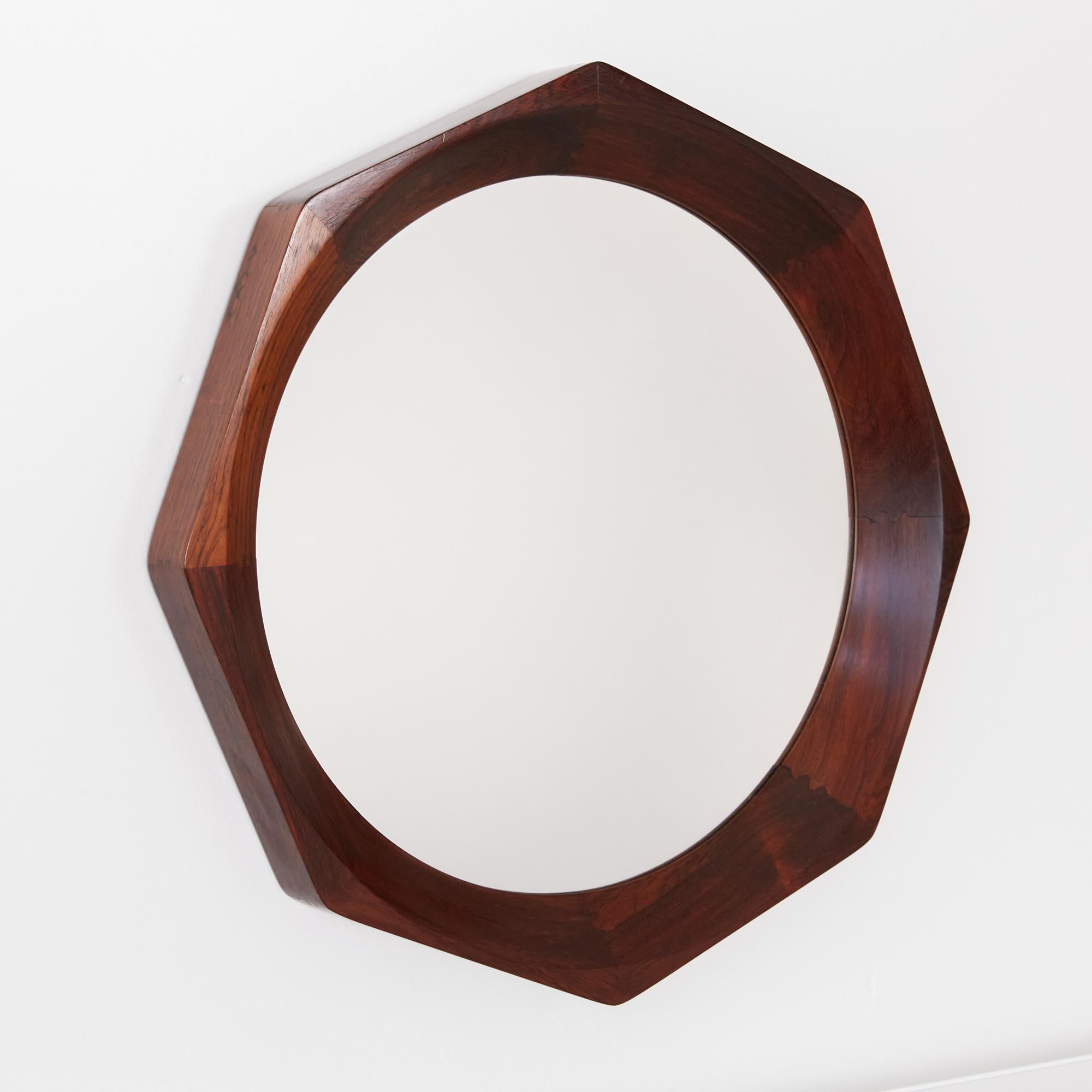 Octagonal rosewood wall mirror by BVK, Denmark, circa 1960s. The mirror features an oiled concave rosewood frame with exposed joinery details and is marked [Made in Denmark]. BVK was best known for making furniture and decor for the notable Danish
