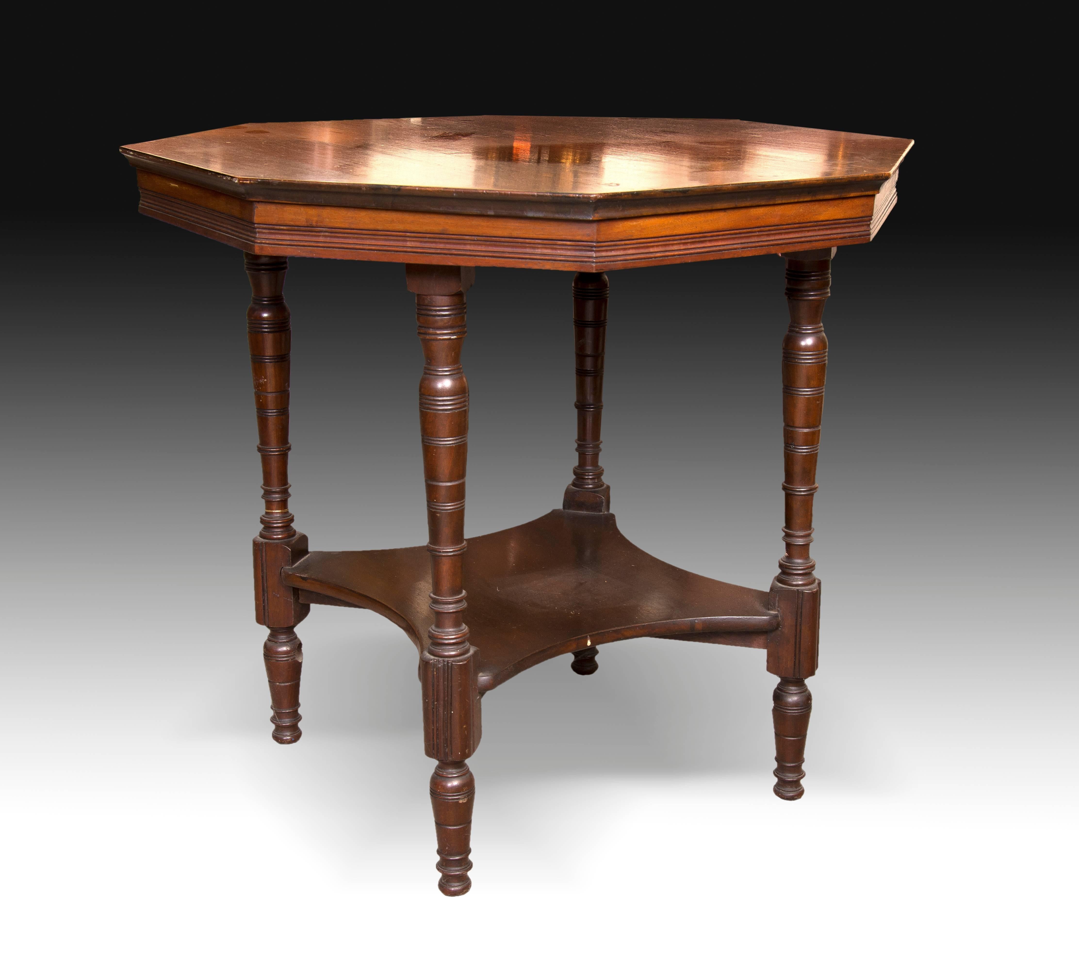 Side table with octagonal straight board, made of rosewood combined with another tone to enhance the first. The four legs, turned with lines, are joined with a flat rhomboidal chambrane. The decoration has been reduced to enhance the quality of the