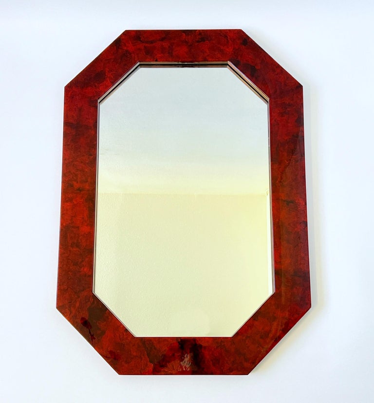 Glamorous 1980’s octagonal shape red stain lacquered burl wood wall mirror. 
Measurements: 39” high, 27.5” wide, 1.5” deep.
