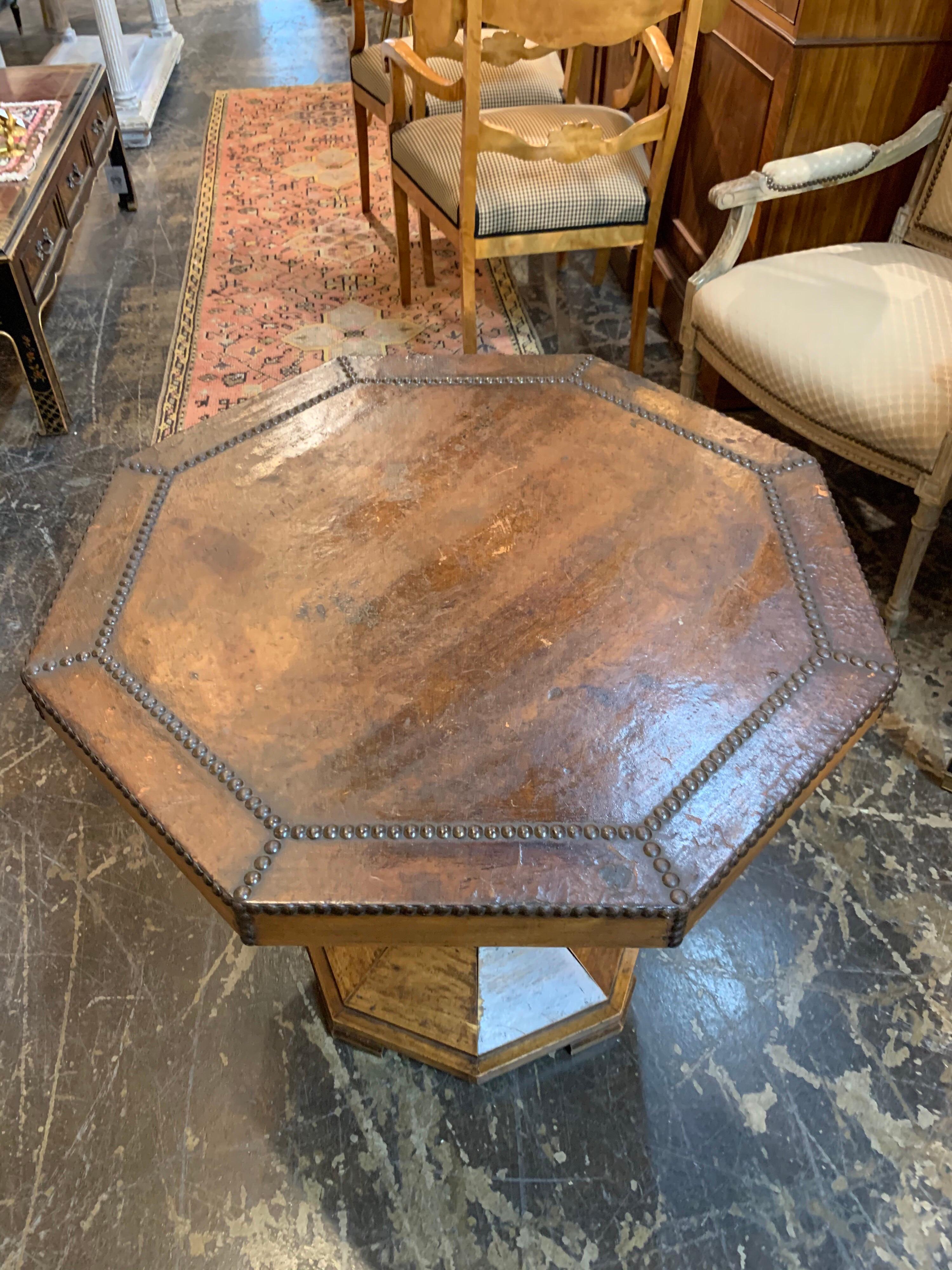 Very handsome table with carved base. The top of the table is leather with nailheads. Would be great in a study or library. So pretty!
