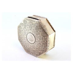 Scatola ottagonale d'argento con rilievi che circondano il cartoncino del Monogram sul coperchio incernierato