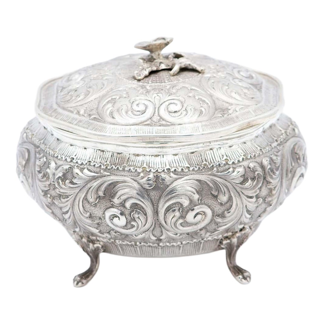 Plaque octogonale en argent avec reliefs, couvercle à bouton de fleur et quatre pieds griffes. en vente