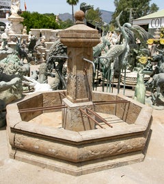Fontaine de jardin octogonale en pierre, avec une colonne centrale et quatre becs