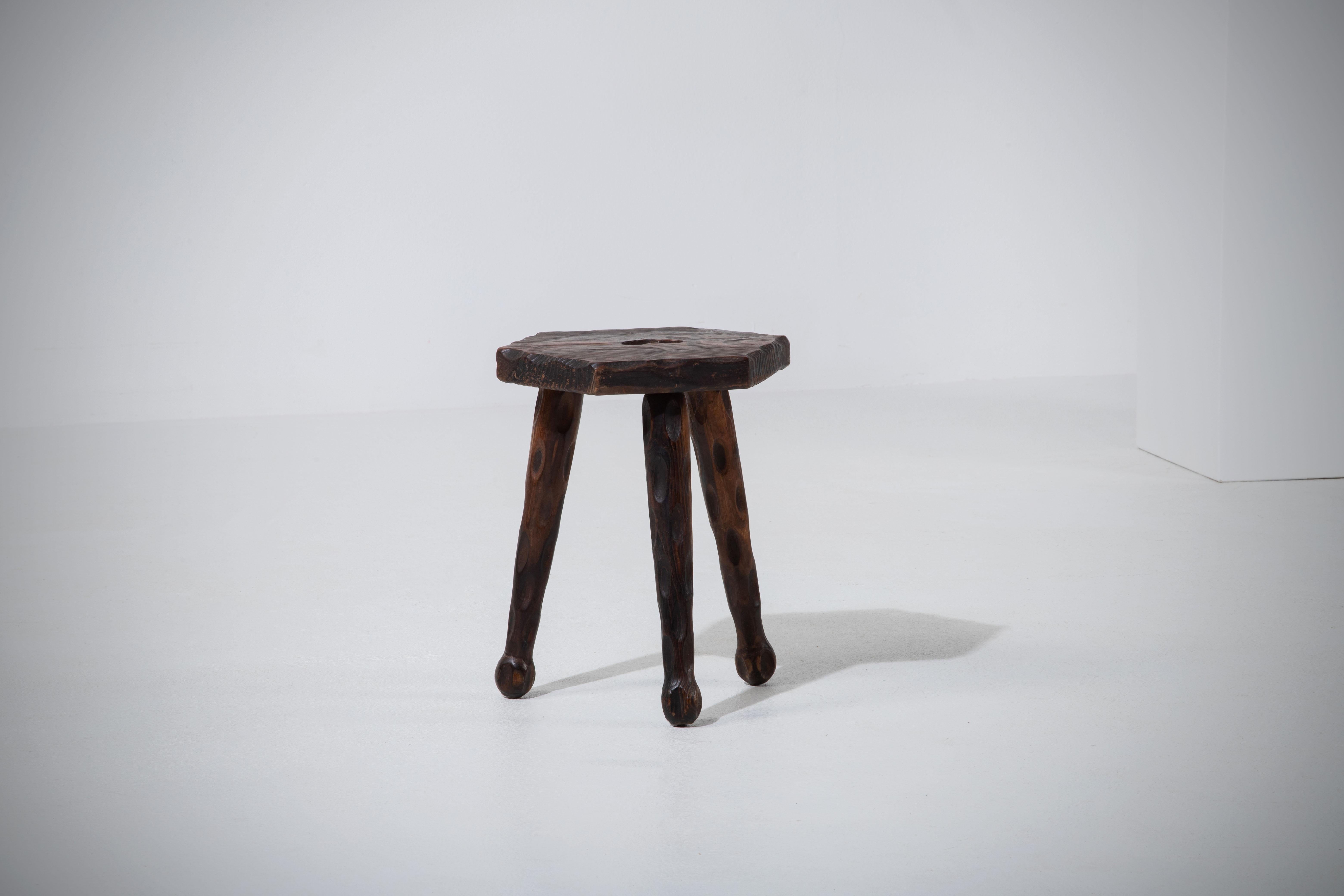 Introducing a fantastic midcentury wooden stool, crafted in France during the 1950s. This piece is constructed without hardware, boasting an elegant octagonal seat and gracefully tapered legs, all made from rich pine wood. The legs end with a unique