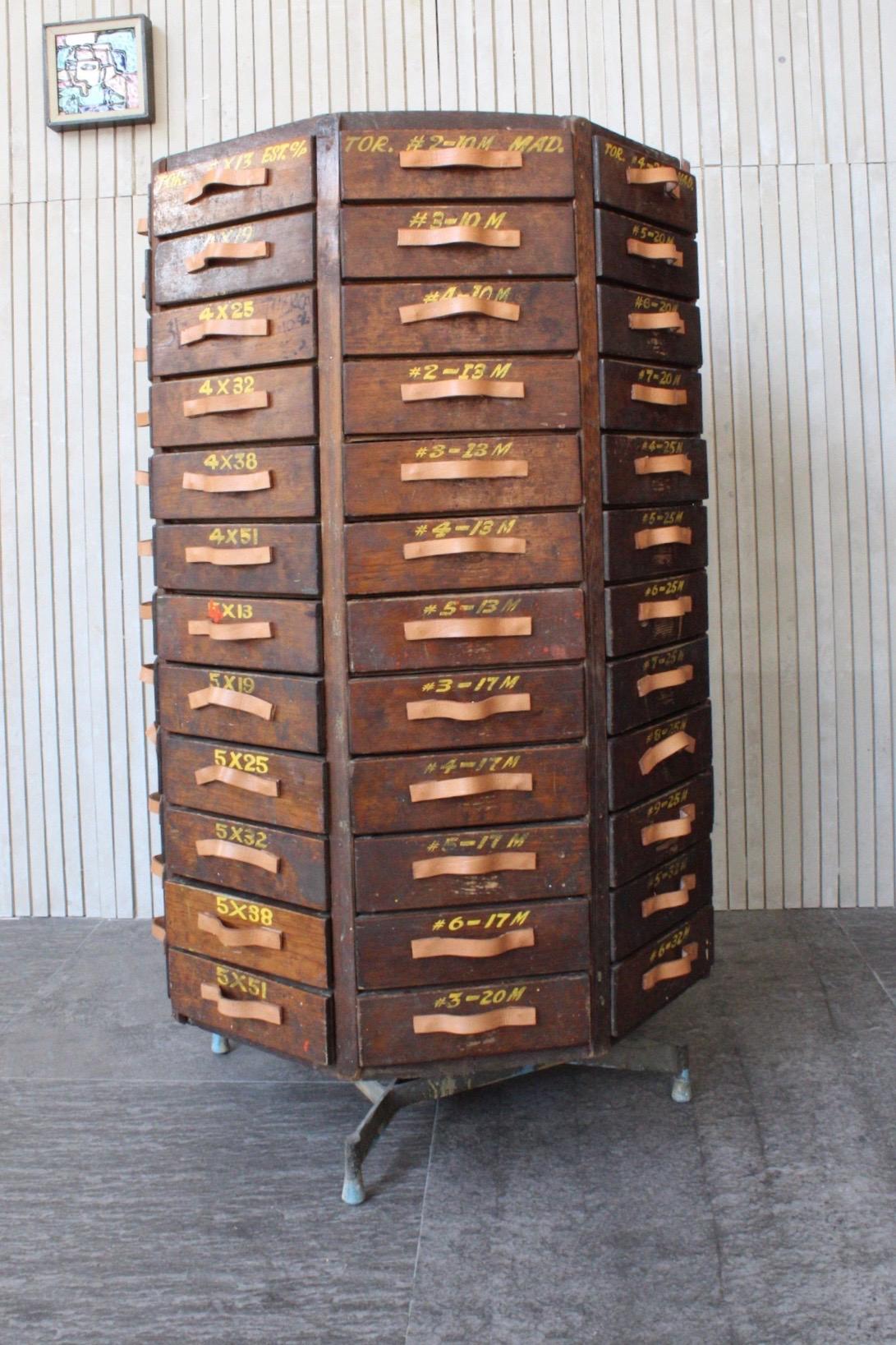 The piece is made at the end of the 1960s, it was part of the fixed assets of a hardware store and there they stored screws, it is made of pine with 96 drawers in a trapezoid shape, the handles are leather (new made in our workshop), the rotation is
