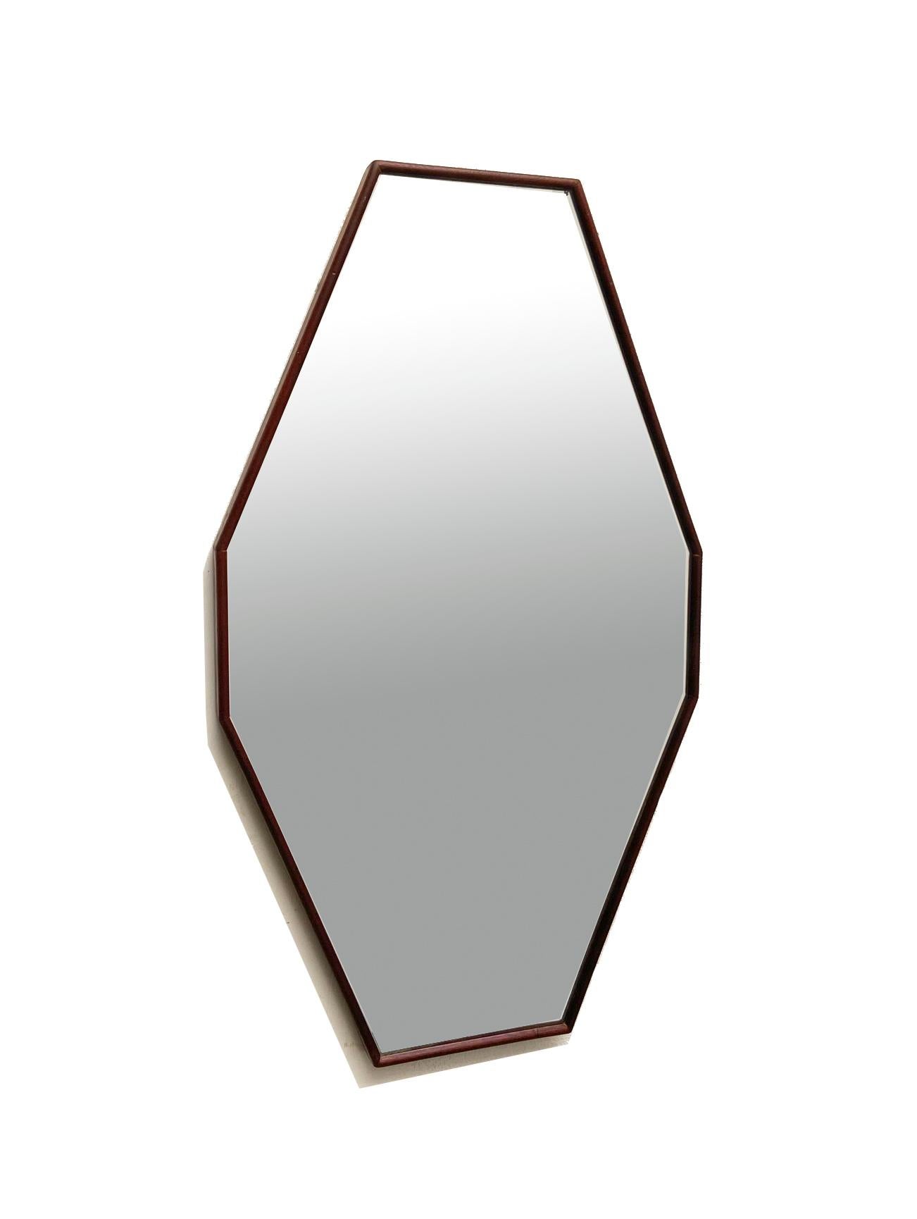 Miroir italien des années 1960, de forme octogonale allongée. 
Cadre en teck, miroir argenté d'origine. 
Très bon état. Signes naturels de vieillissement.