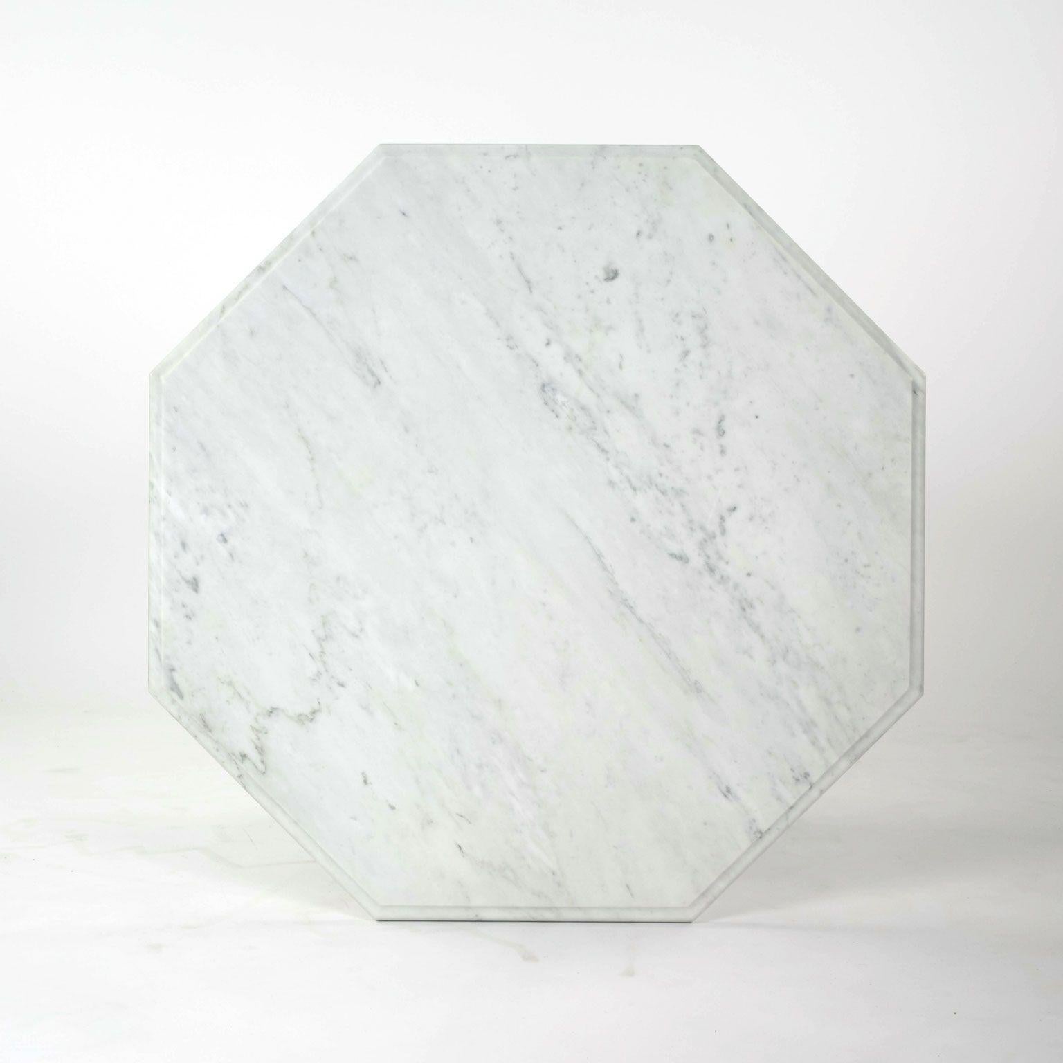Octagonal top dining table, or center table, in Carrara marble. Octagonal shape 1.13 inch thick top resting on a tapered mitered edge octagonal base.