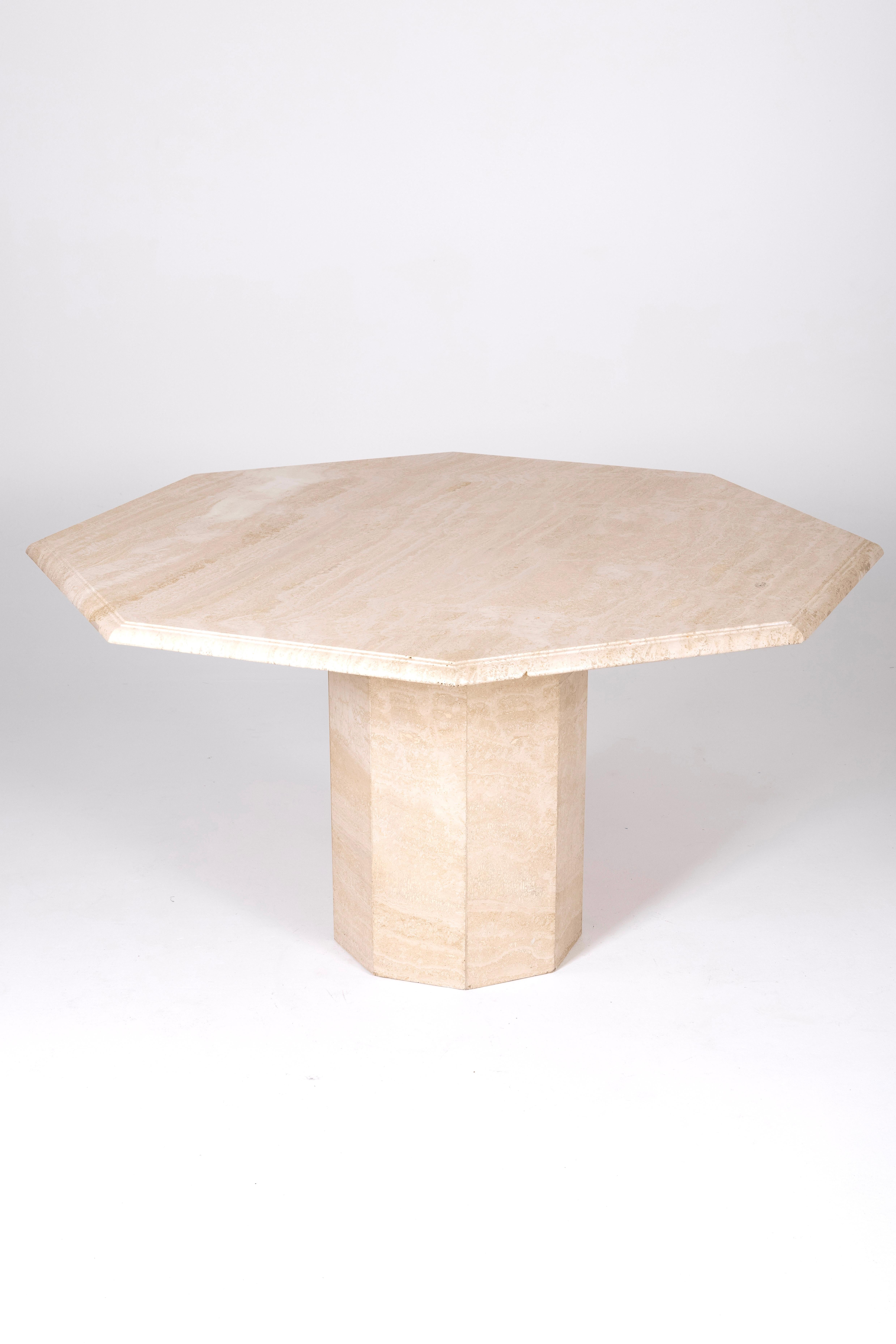 1970s octagonal travertine dining table. The tabletop and base can be separated. Some chips on the tabletop to note. Also known as 'Tuf,' travertine is a natural sedimentary limestone rock that complements well with wood, marble, or metal.

LP1486