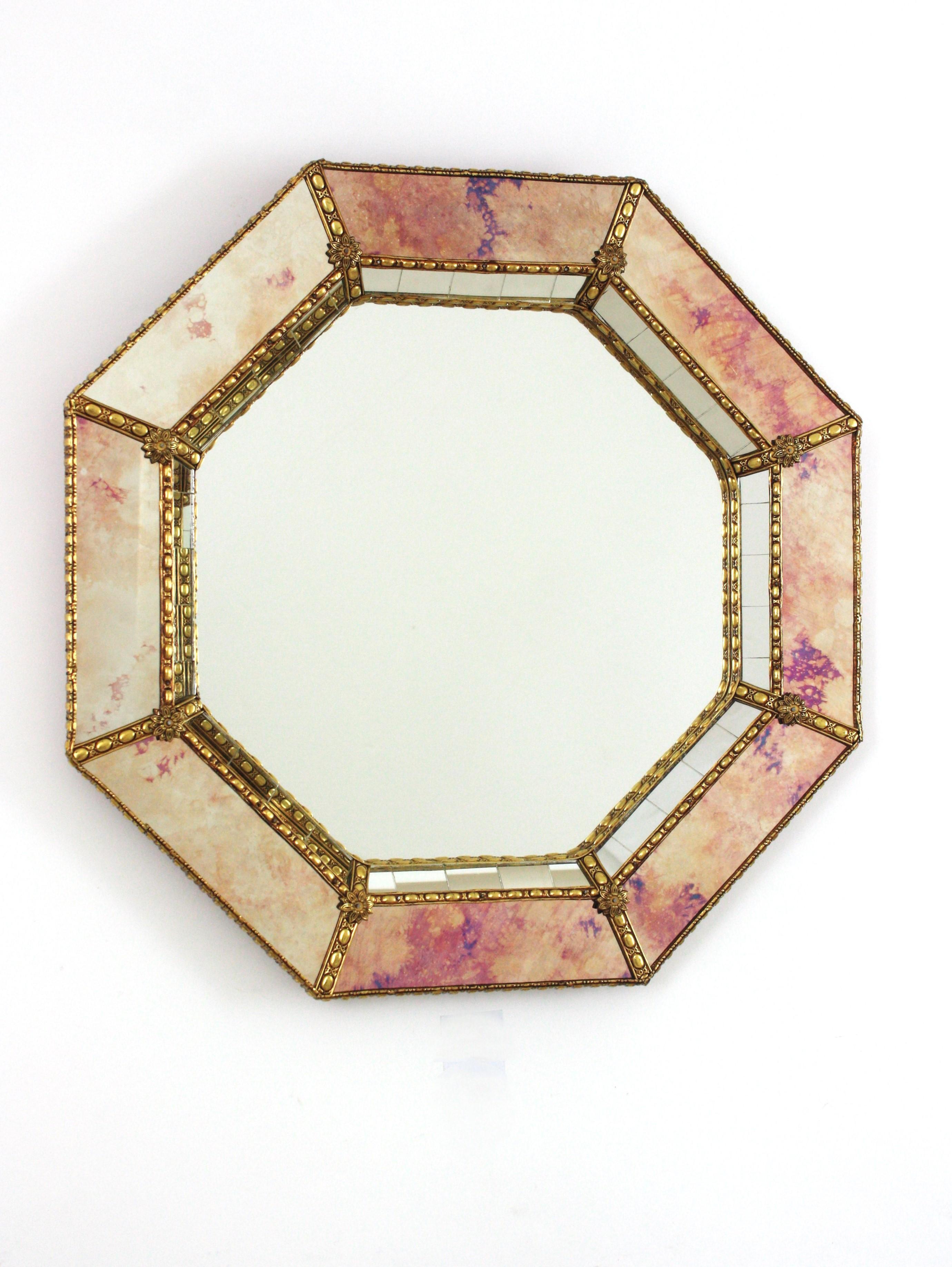 Superbe miroir octogonal de style vénitien Hollywood Regency avec des panneaux en verre irisé et miroir. Espagne, années 1960
Ce miroir mural glamour présente un cadre à double couche en laiton. Forme octogonale avec deux couches de miroirs à