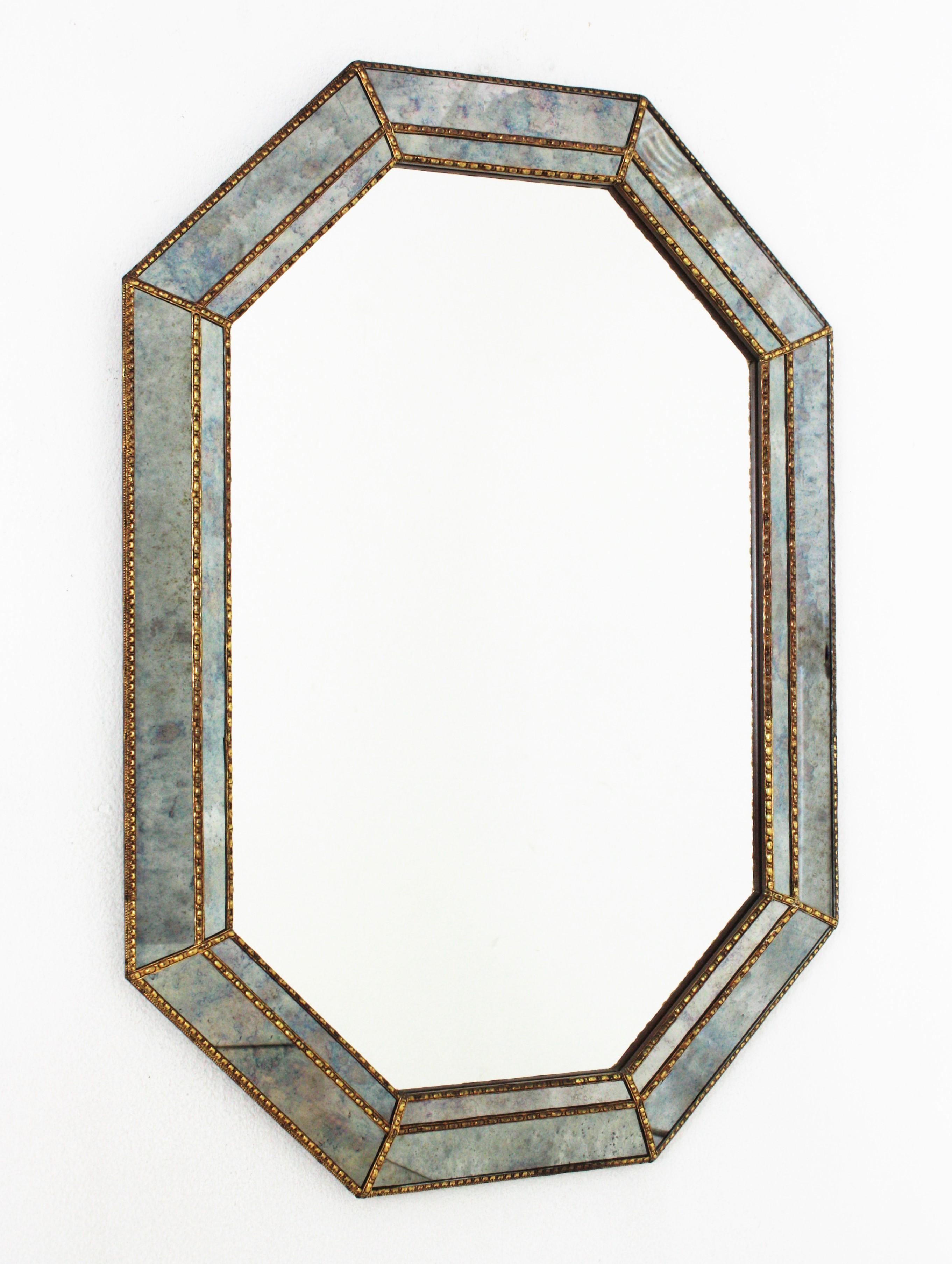 Cool Venetian Modern octagonal mirror with blue iridiscent mirror glass panels. Spain, 1960s
Glamorous mirror featuring a double layered mirror frame made of brass. Octagonal form with a frame that has two layers of decorative paneled mirrors. Both