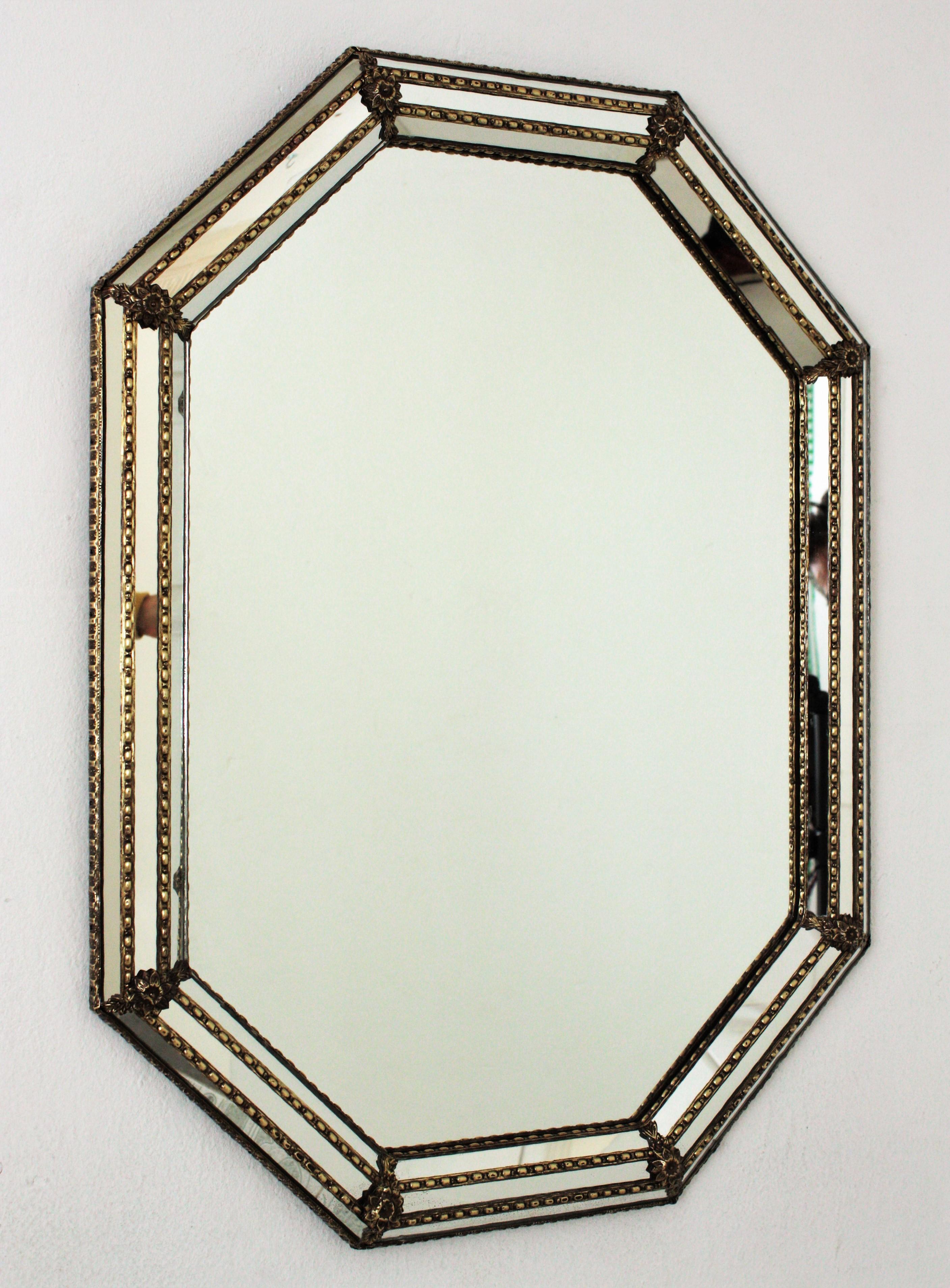 Venetian style octagonal wall mirror with gilt metal accents, Spain, 1950s
This octagonal mirror has a triple mirror frame. The mirrored panels are adorned by metal patterns and flowers.
This wall mirror will be perfect in a contemporary or