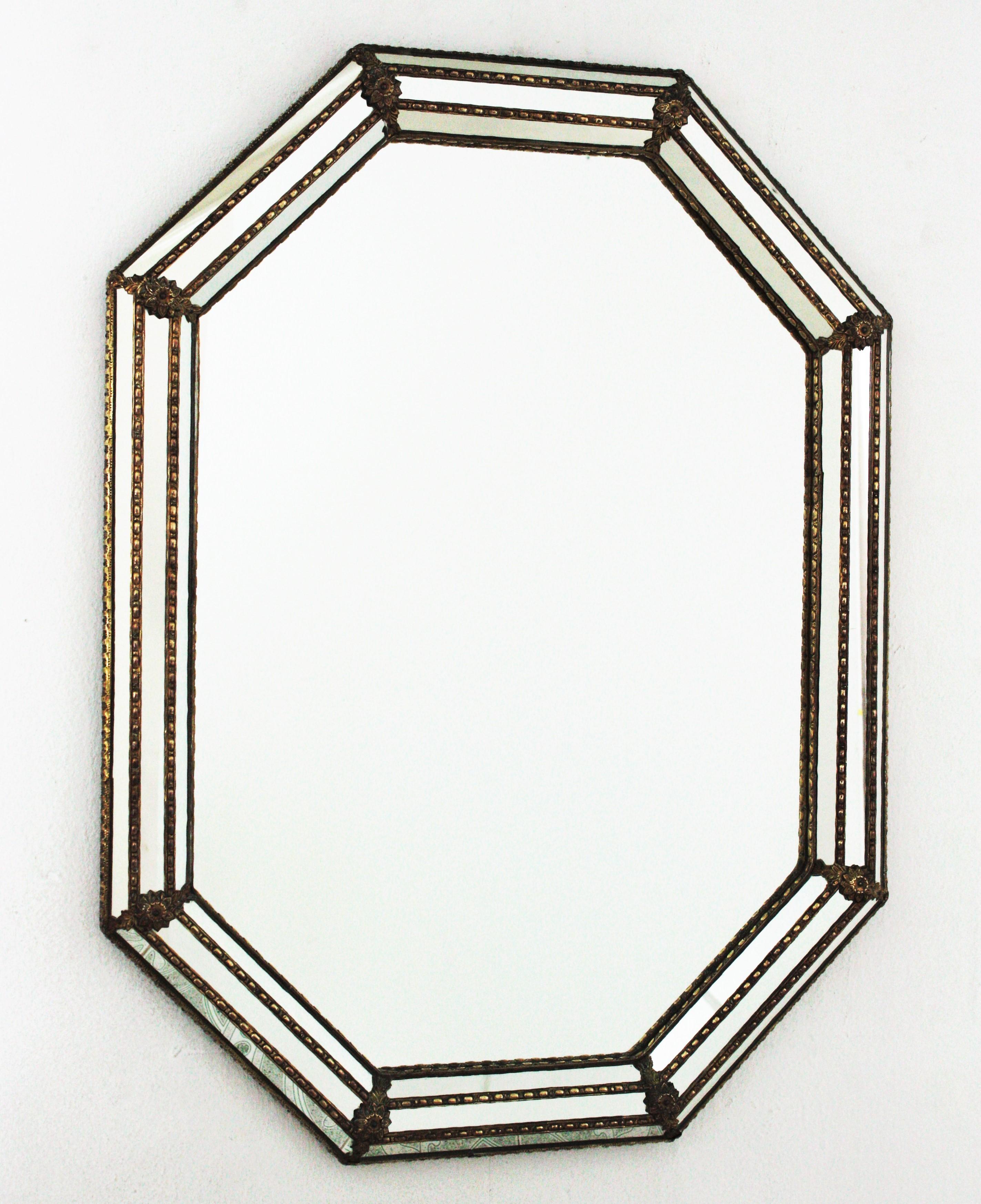 Venetian style octagonal wall mirror with gilt metal accents, Spain, 1950s
This octagonal mirror has a triple mirror frame. The mirrored panels are adorned by metal patterns and flowers.
This wall mirror will be perfect in a contemporary or