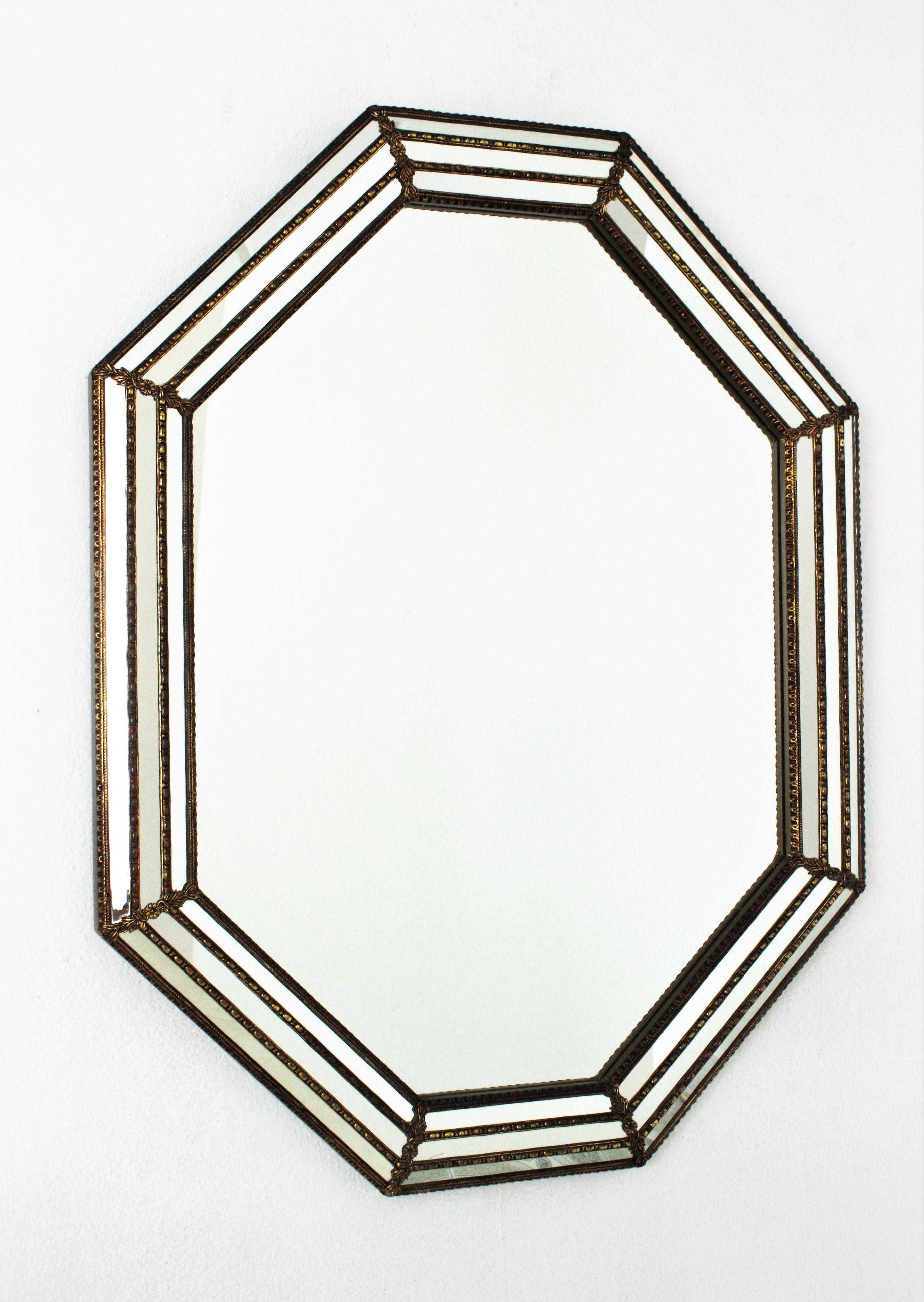 Venetian style octagonal wall mirror with gilt metal accents, Spain, 1950s
This octagonal mirror has a triple mirror frame. The mirrored panels are adorned by metal patterns and small flowers.
This wall mirror will be perfect in a contemporary or