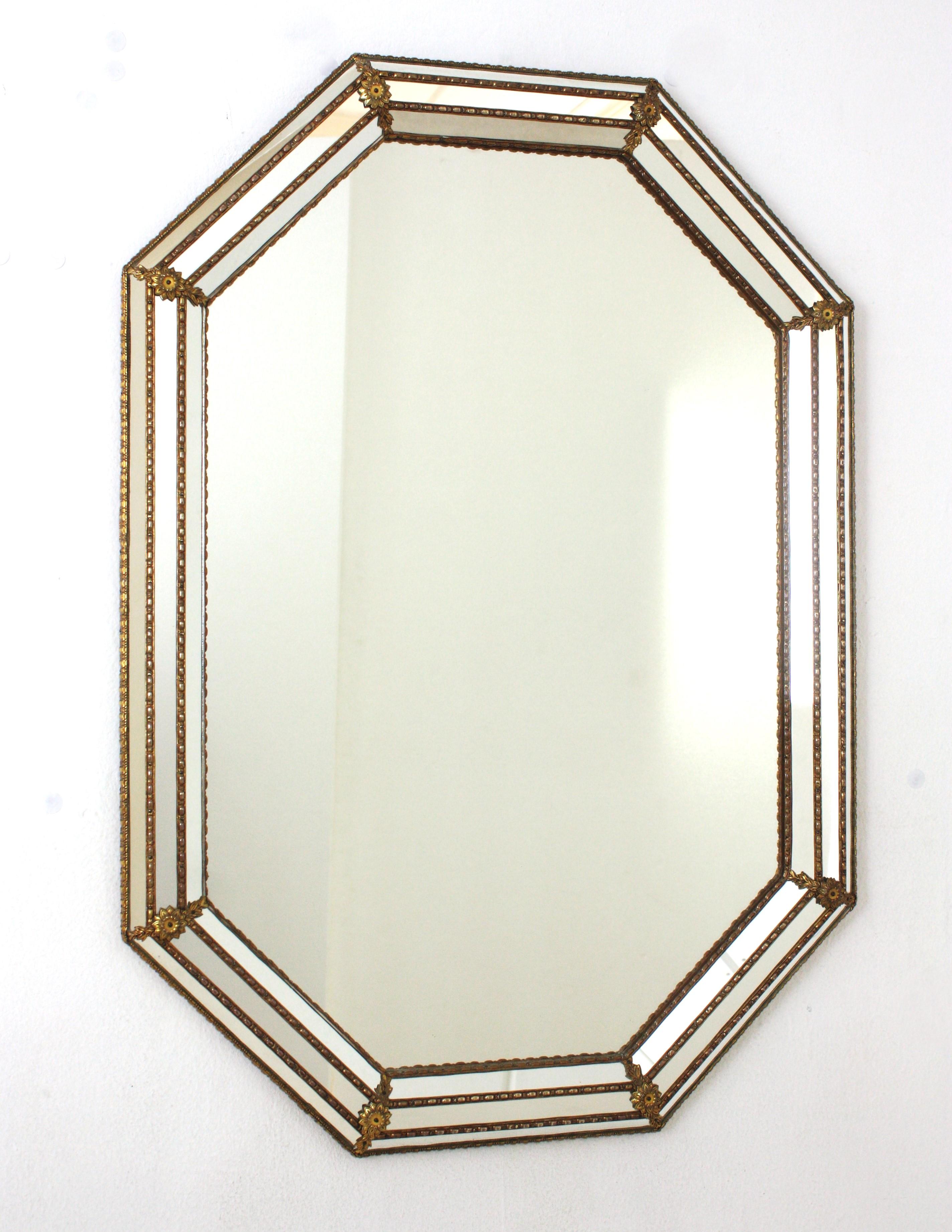 Venetian Modern Octagonal Wall Mirror with Brass Frame
Venetian style octagonal wall mirror with gilt metal accents, Spain, 1960s
This octagonal mirror has a triple mirror frame. The mirrored panels are adorned by metal patterns and small