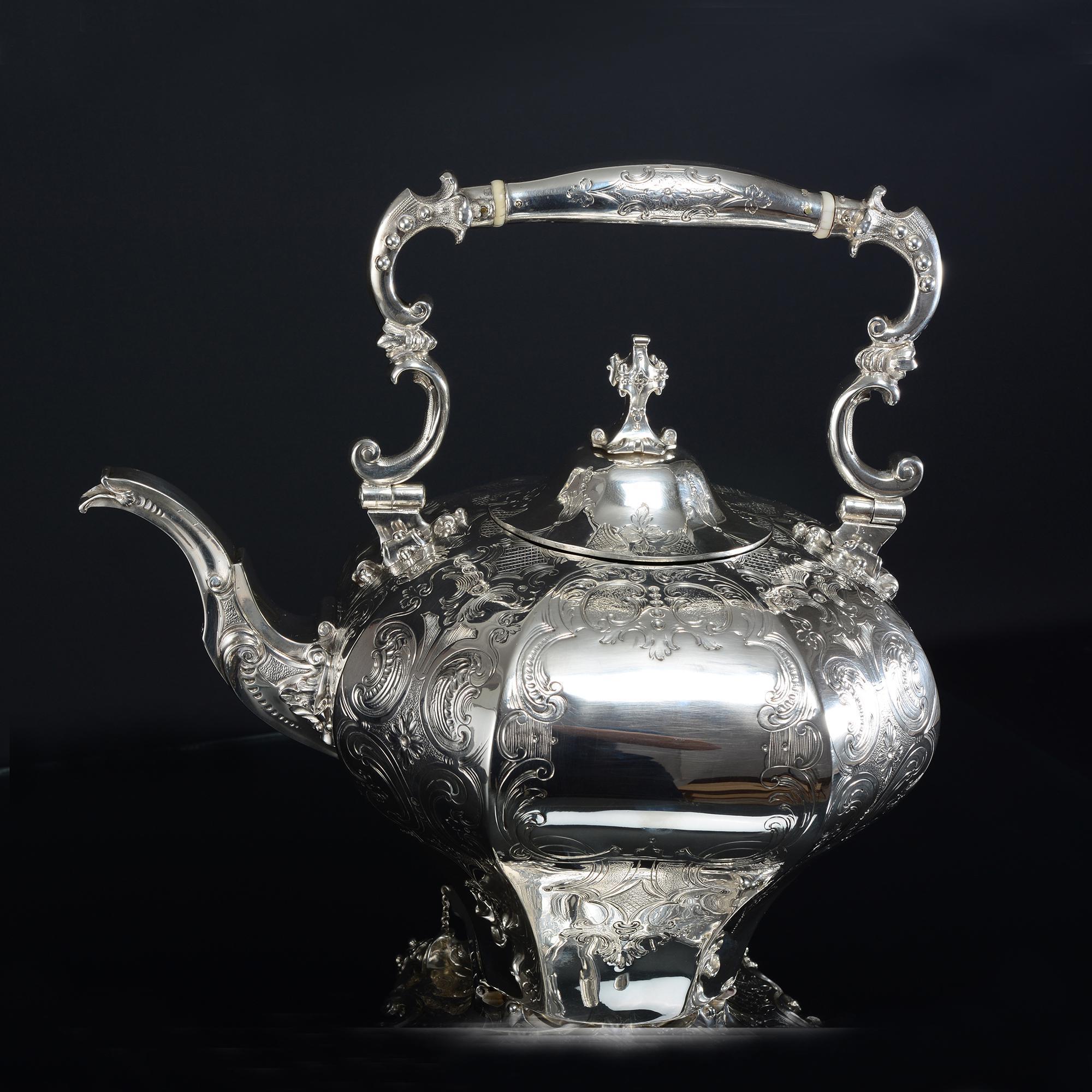Superb Victorian silver kettle, octagonal in form with beautifully hand-chased decoration of scrolls, stylised leaves and flower heads. The silver kettle's body is mounted on a cast and hand-chased, four-legged frame and is held in place by two