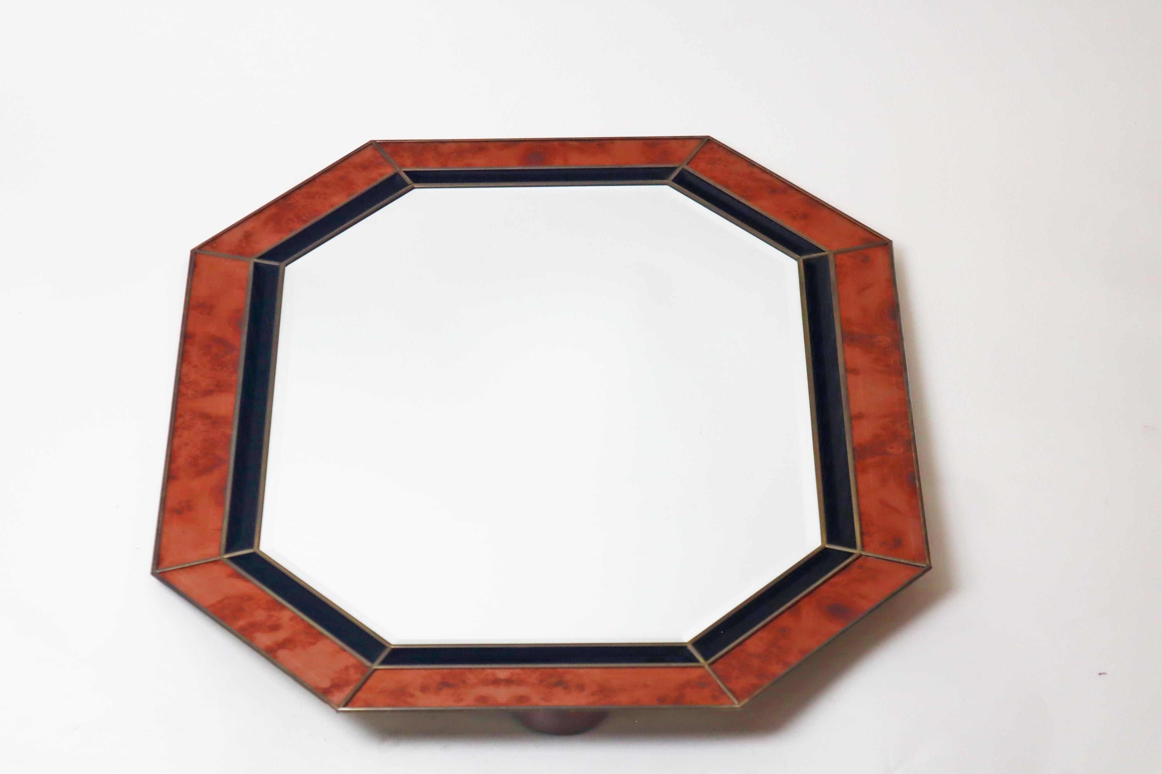 This large octagonal wall mirror is a real gem! The mirror glass was lovingly hand-set in brass, and all the glass elements are faceted. The outer glass has a beautiful burl wood look, which gives this mirror a timeless elegance that will surely be