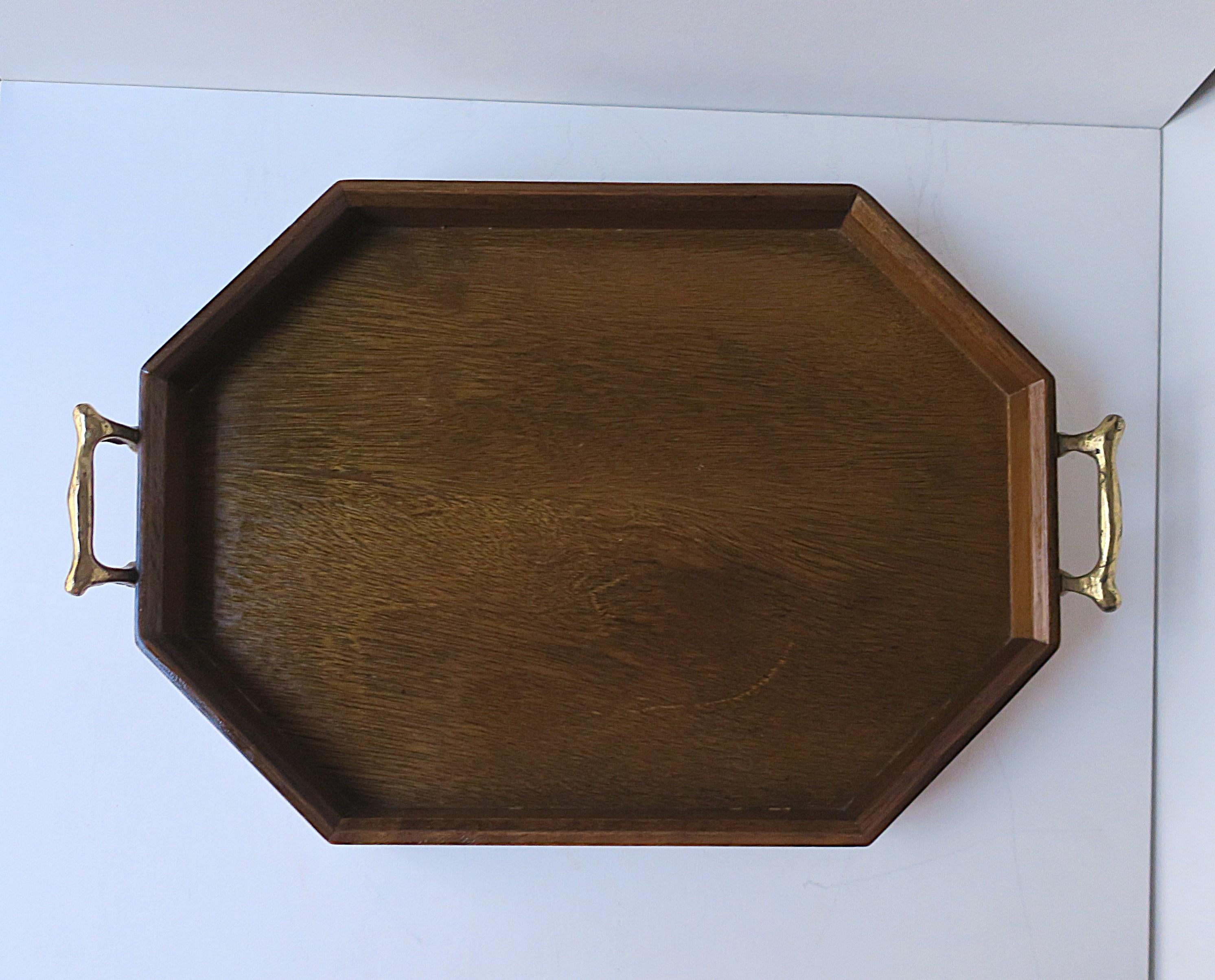 Vassoio da portata ottagonale d'epoca in legno e ottone, anni '60 circa. Il vassoio, di forma ottagonale, ha un bordo a galleria in legno coordinato e maniglie in ottone su entrambe le estremità. Ottimo per servire o per esporre un oggetto, etc.

I