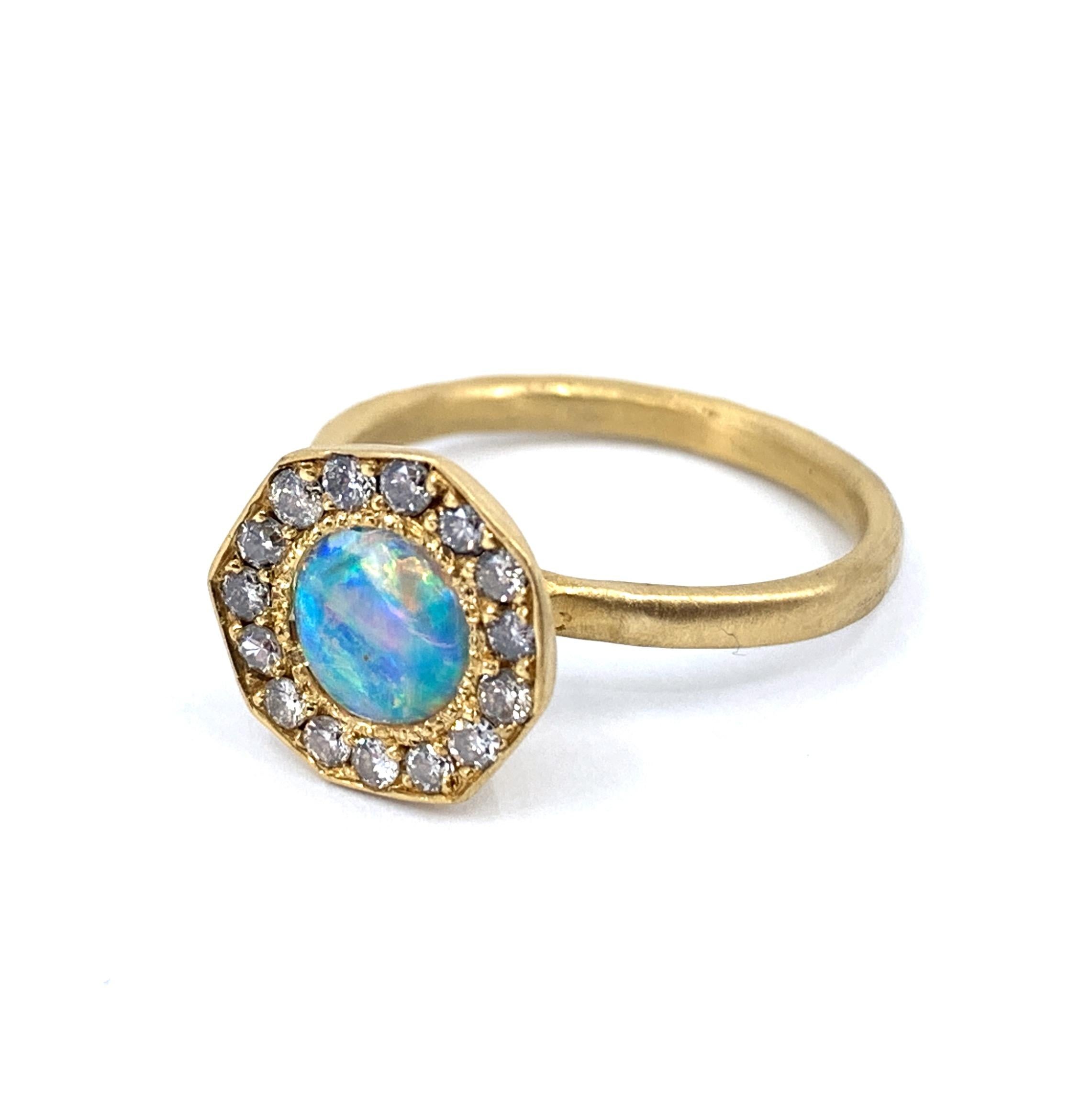 Eytan Brandes made this appealing little ring to show off a particularly fiery Australian opal.  The stone is only about 6mm in diameter -- estimated at 0.30 carats -- but is bursting with life and color.  Surrounding it are 15 bright, good-quality