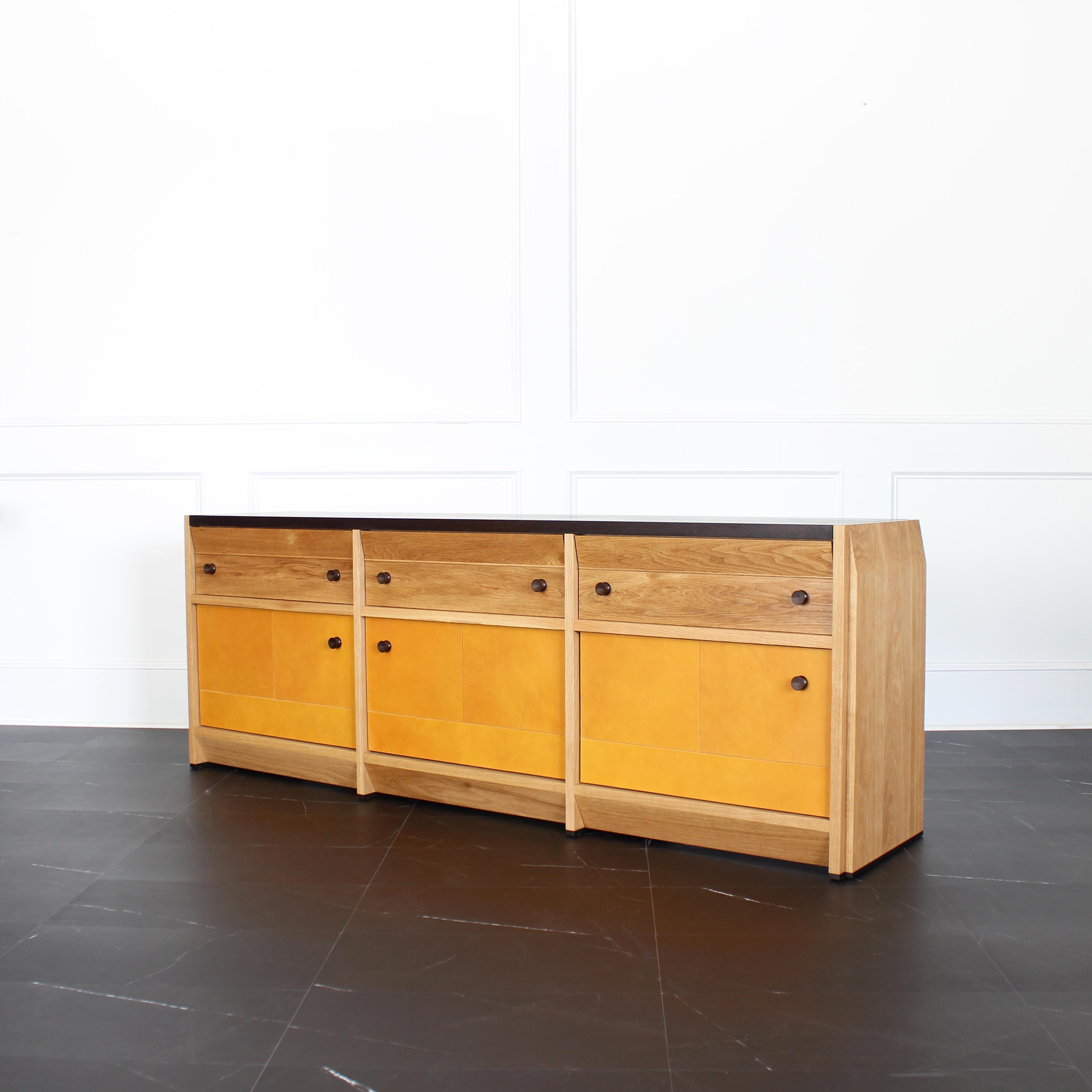 The Octavia Credenza by Crump and Kwash 

Features a solid wood case / oiled or acrylic finish / patinated solid brass pulls / premium, full extension, soft close drawer slides / solid maple, dovetailed drawer boxes / veg tan leather door panels /