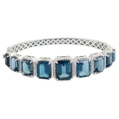 Graduated Octogen Shaped Blue Topaz Oval Bangle With Diamonds In 14k White Gold