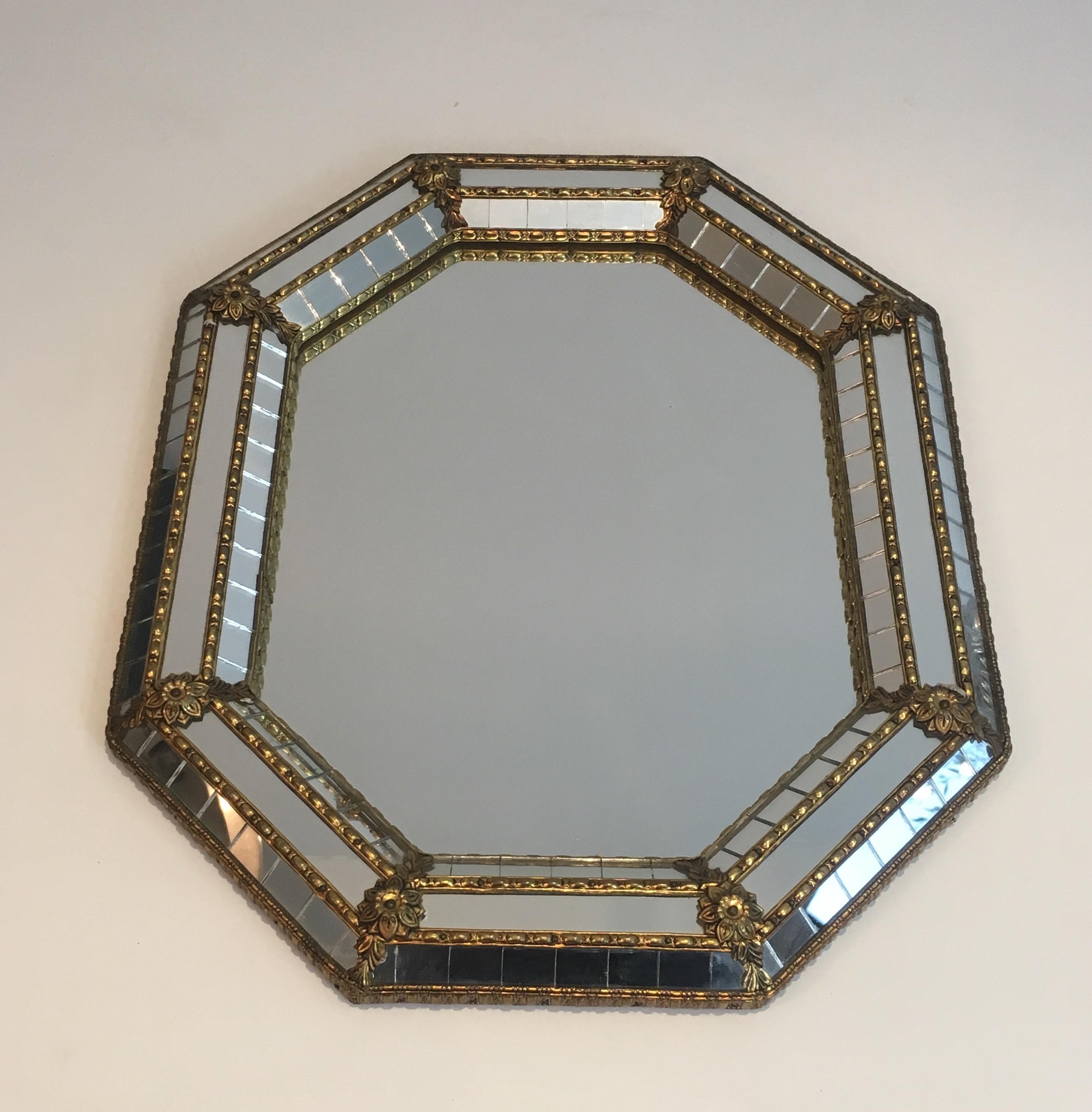 This small octogonal neoclassical style mirror is made of brass garlands and flowers with a marquetry of small faceted mirrors. This is a French work, circa 1970.
      
