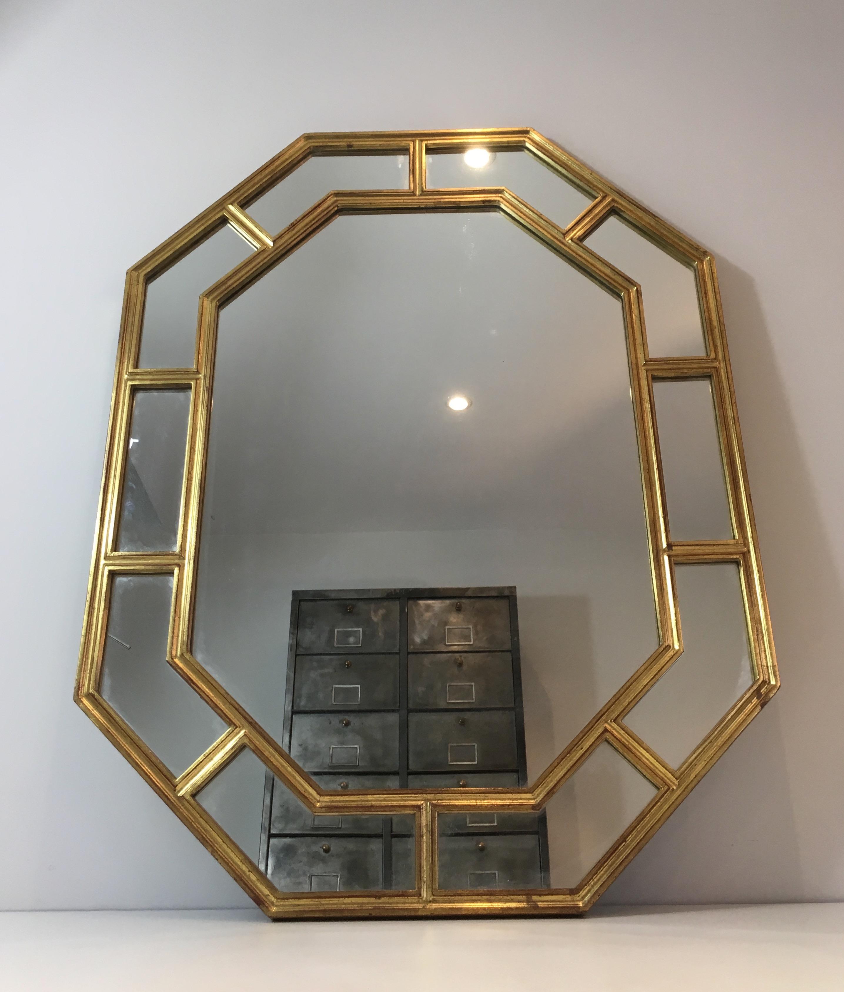 This octagonal mirror is made of gilt resin and mirrors. This is a French work, circa 1970.