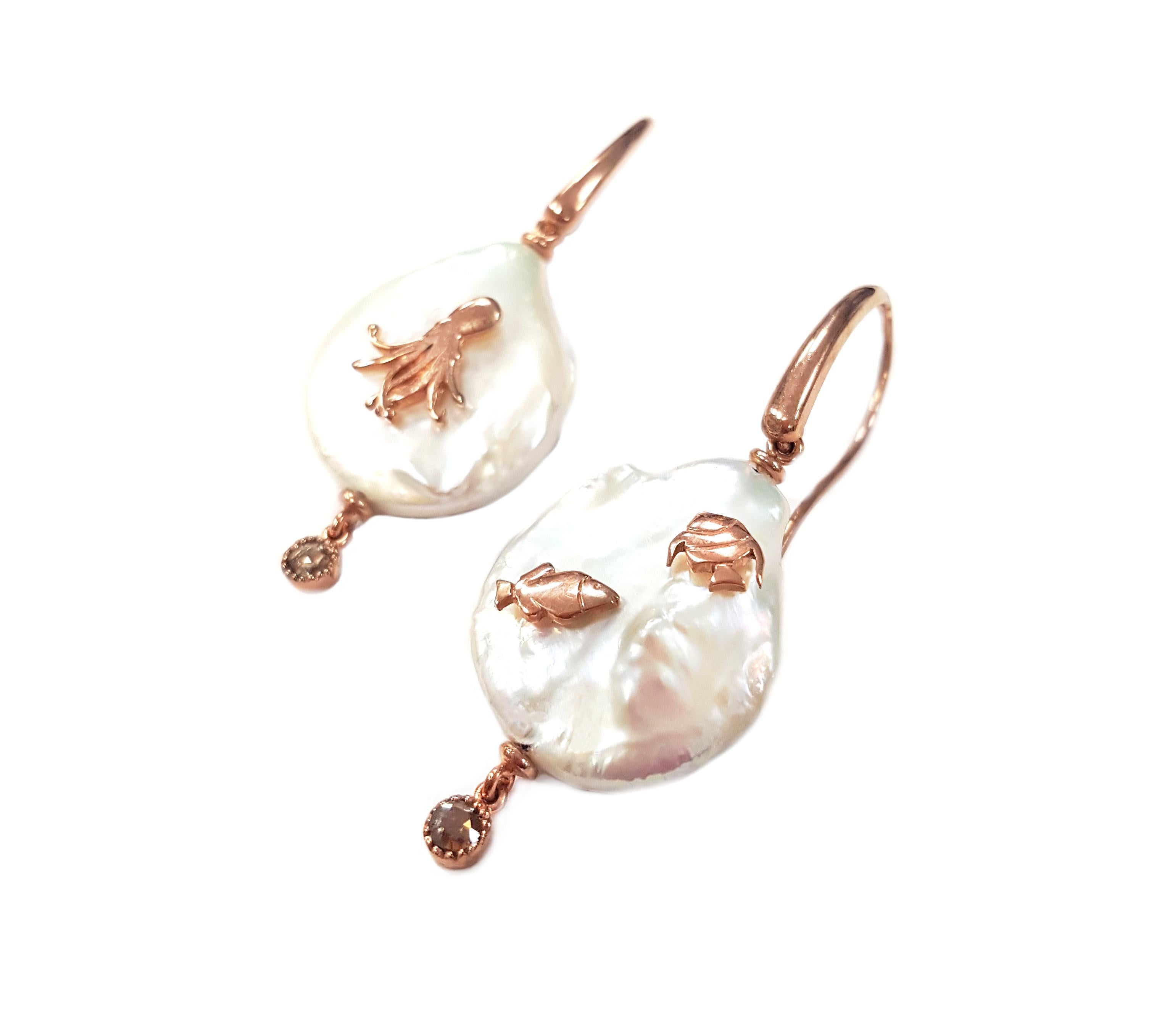 These delightfully whimsical earrings feature three 3-dimensional sea creatures created from 18-karat rose gold: an octopus and two fish are silhouetted against a luminous pearl. They are masterfully hand-made and feature a single rose-cut diamond,