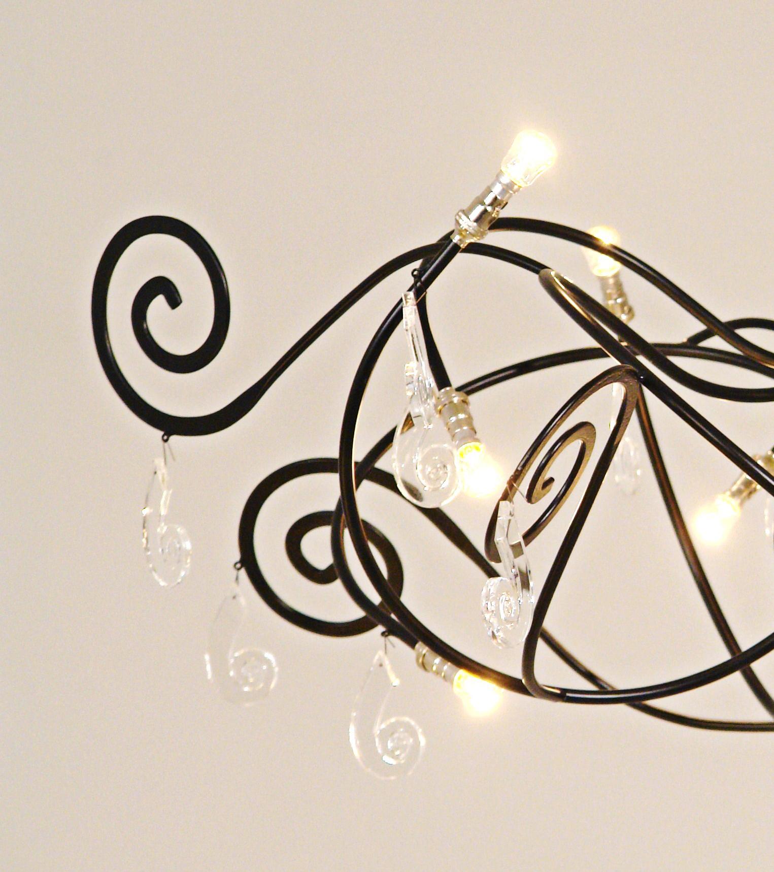 Elegant chandelier diameter ca. 100 cm height 60 cm with 12 bulbs and glass prisms designed in Maroeska Metz’s own style: with the curl. Delivered with a hanging rod and ceiling plate in the same color.