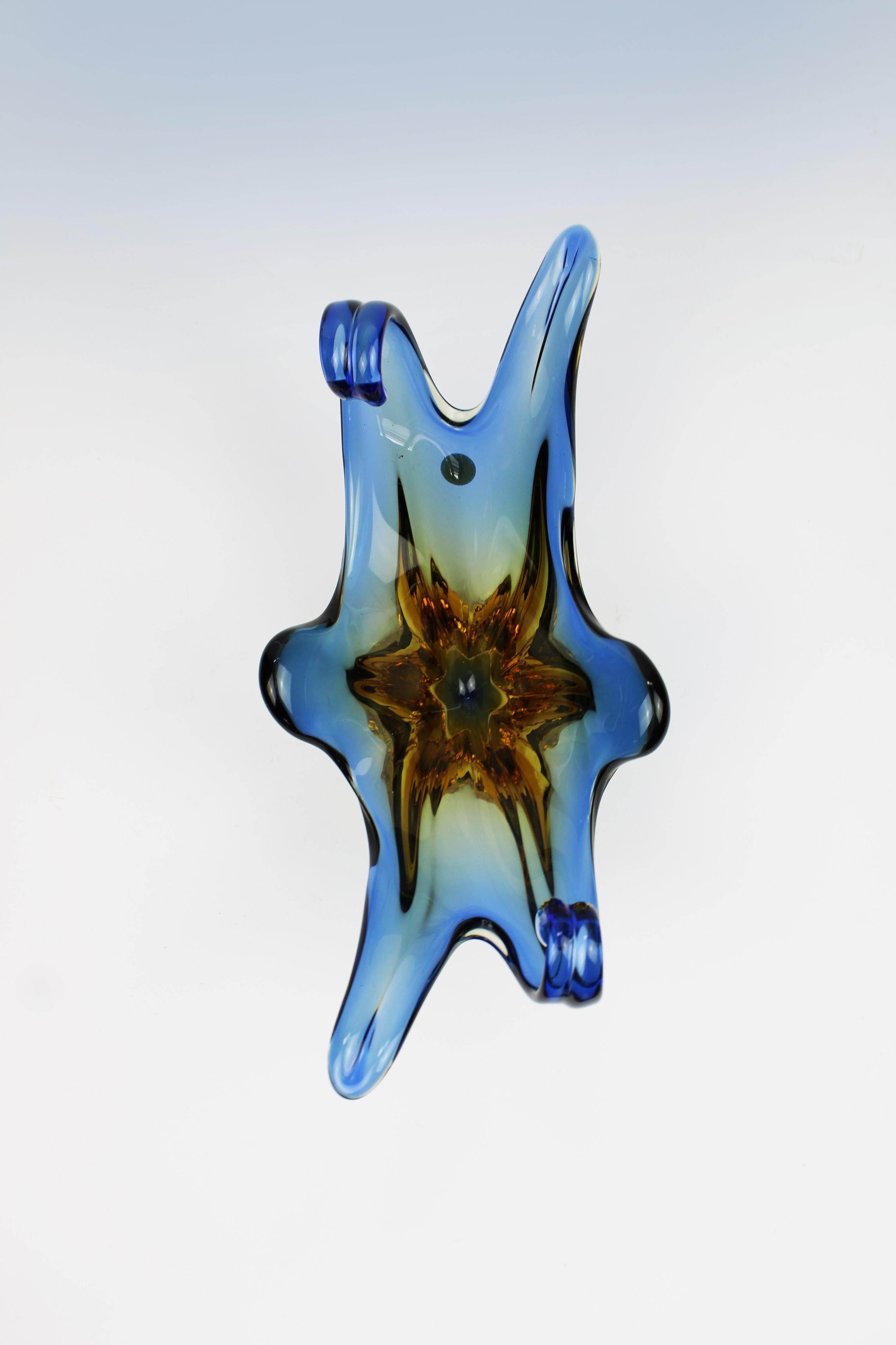 Introducing a striking octopus-shaped Murano bowl, a captivating piece of 20th-century Italian glass artistry. This organic design features vibrant blue and orange hues, masterfully blended to create a dynamic and eye-catching appearance. The