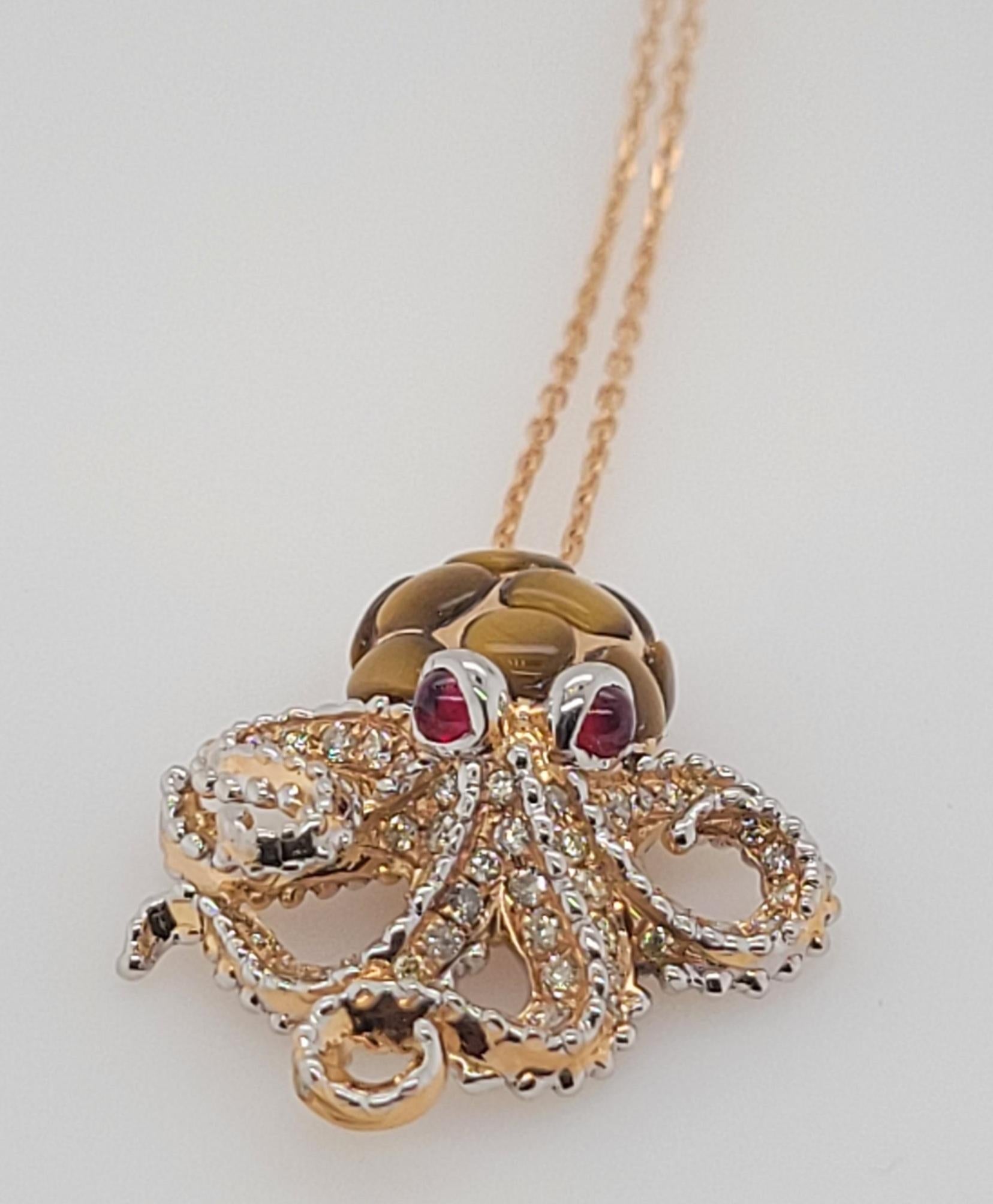 Pendentif pieuvre en or 18K Oeil de tigre, rubis et diamants 
Avec six bras pour vous tenir, vous tomberez sous le charme de ce pendentif pieuvre, qui fait partie de nos collections de merveilles de la mer. Réalisés en or rose 18kt, les bras ondulés