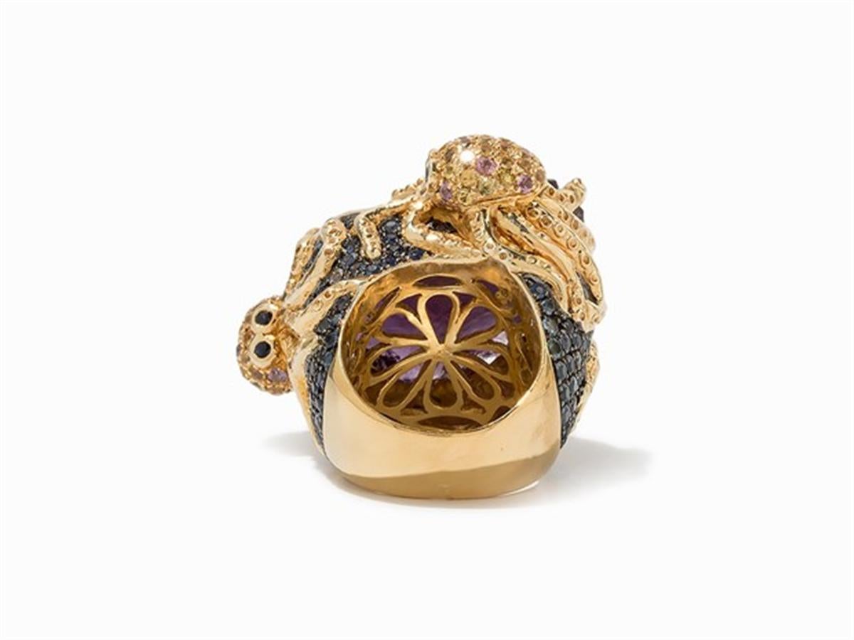  delineation
- Sterling silver, gold-plated
- Hallmarked with the silver standard
- 1 amethyst rough stone, approx. 30 x 22 mm
- Numerous yellow, blue and pink sapphires
- Ring size: 54/55; US 6,8/7,2
- Weight: approx. 37.1 g

Kraken-Ring mit