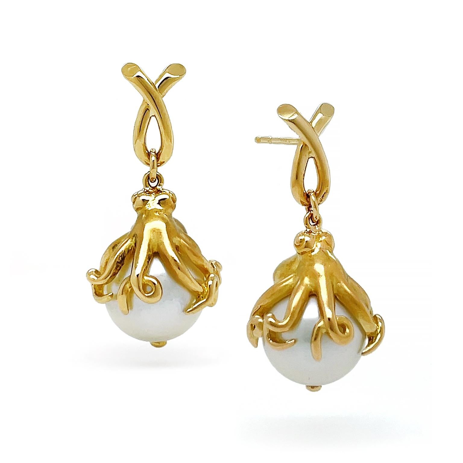 These earrings evoke the spirit of the ocean. An 18k yellow gold loop overlaps to support a descending gold octopus. Detail is given to the eyes of the octopus and its limbs that clutch a round white south sea pearl. A final touch of gold is visible