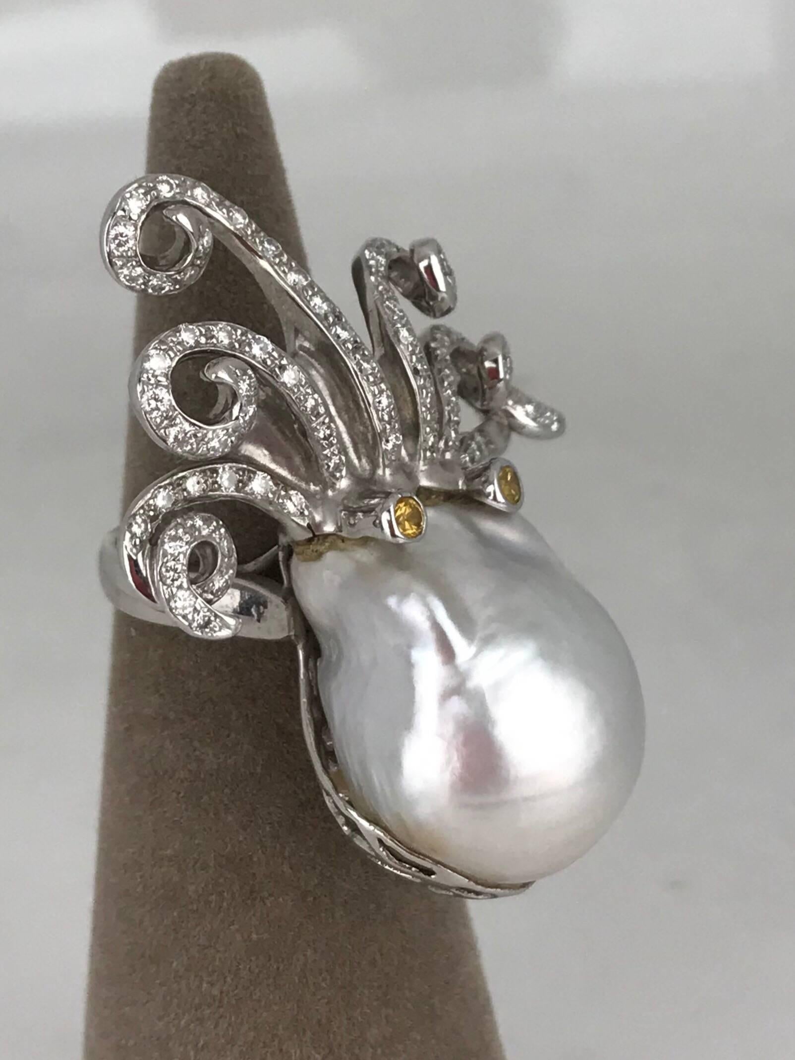 Octopus themed retro ring set in 18 Karat white Gold with an  18 X 24 MM large South Sea pearl featuring curled diamond tentacles and yellow sapphire eyes.

The Pearl measures 18 x 24 mm in diameter and has a high luster with white and silver
