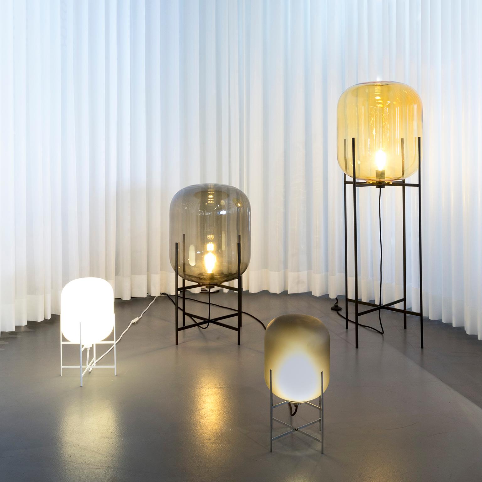 Oda floor lamp - European, Minimalist, Amber, black base, German, 21st century, lamp

Directly inspired by the industrial monuments photographed by the famous artists Bernd and Hilla Becher, Sebastian Herkner bundles up their outer shape and inner