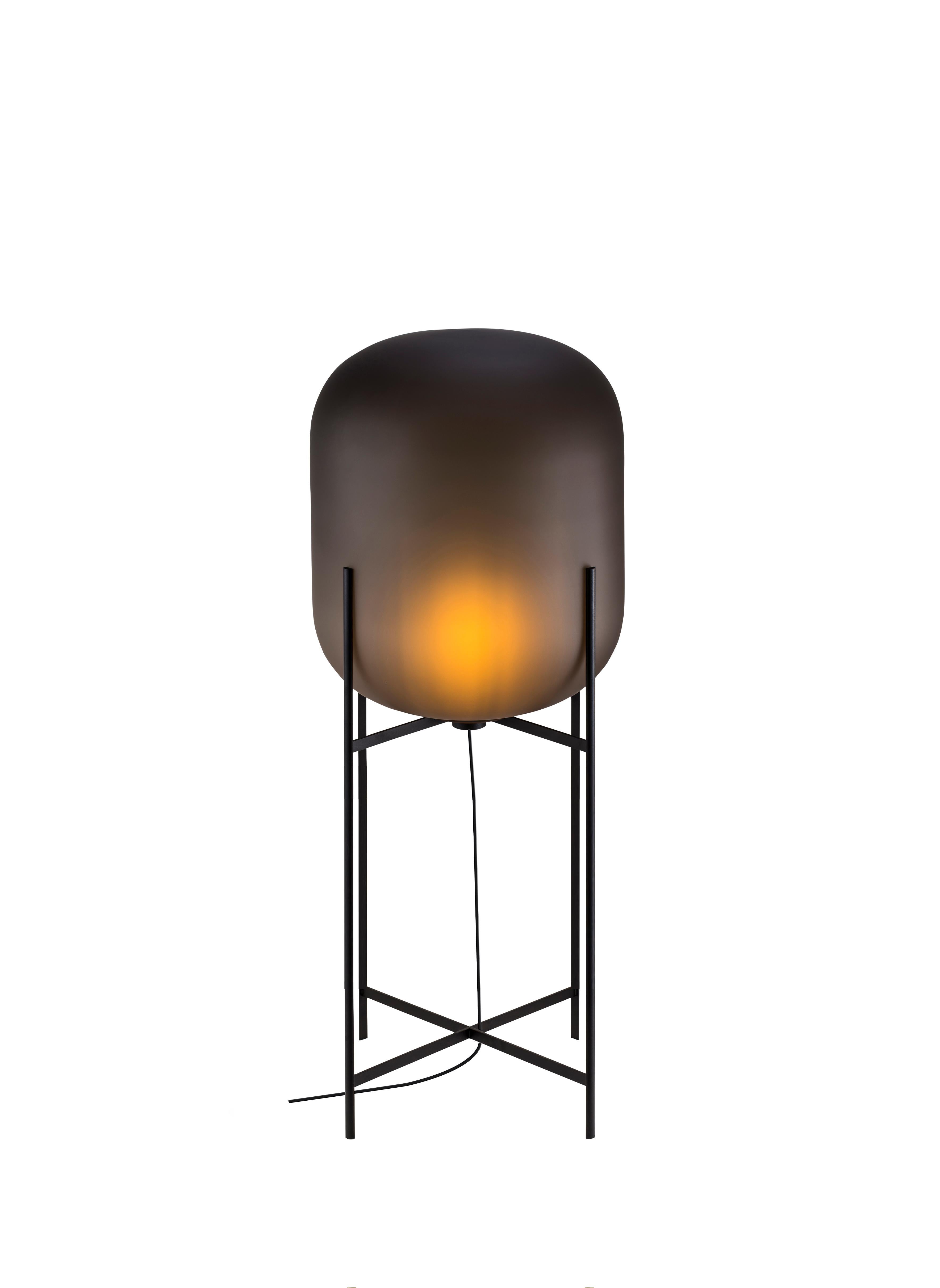 Oda in between smoky grey acetato black floor lamp by Pulpo.
Dimensions: D45 x H111.2 cm
Materials: handblown glass coloured and steel.

Also available in different finishes. Please contact us.

A slender base hugs a bulbous form. An