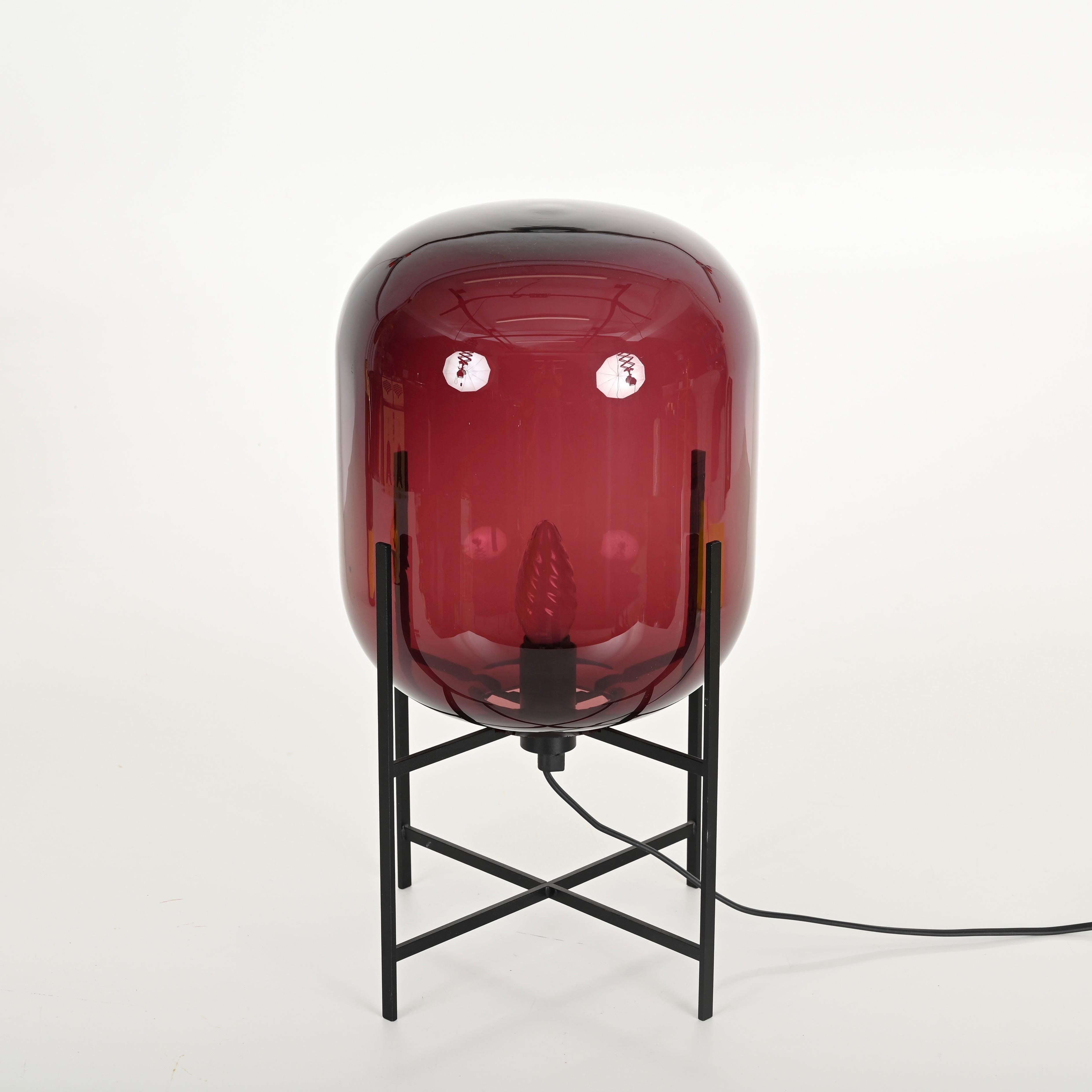Magnifique lampe de table Oda dans le charmant grand modèle en verre soufflé de couleur pourpre foncé.  Cette lampe de table élégante a été conçue par Sebastian Herkner pour Pulpo.

Une pièce emblématique du design contemporain, Inspirée par les