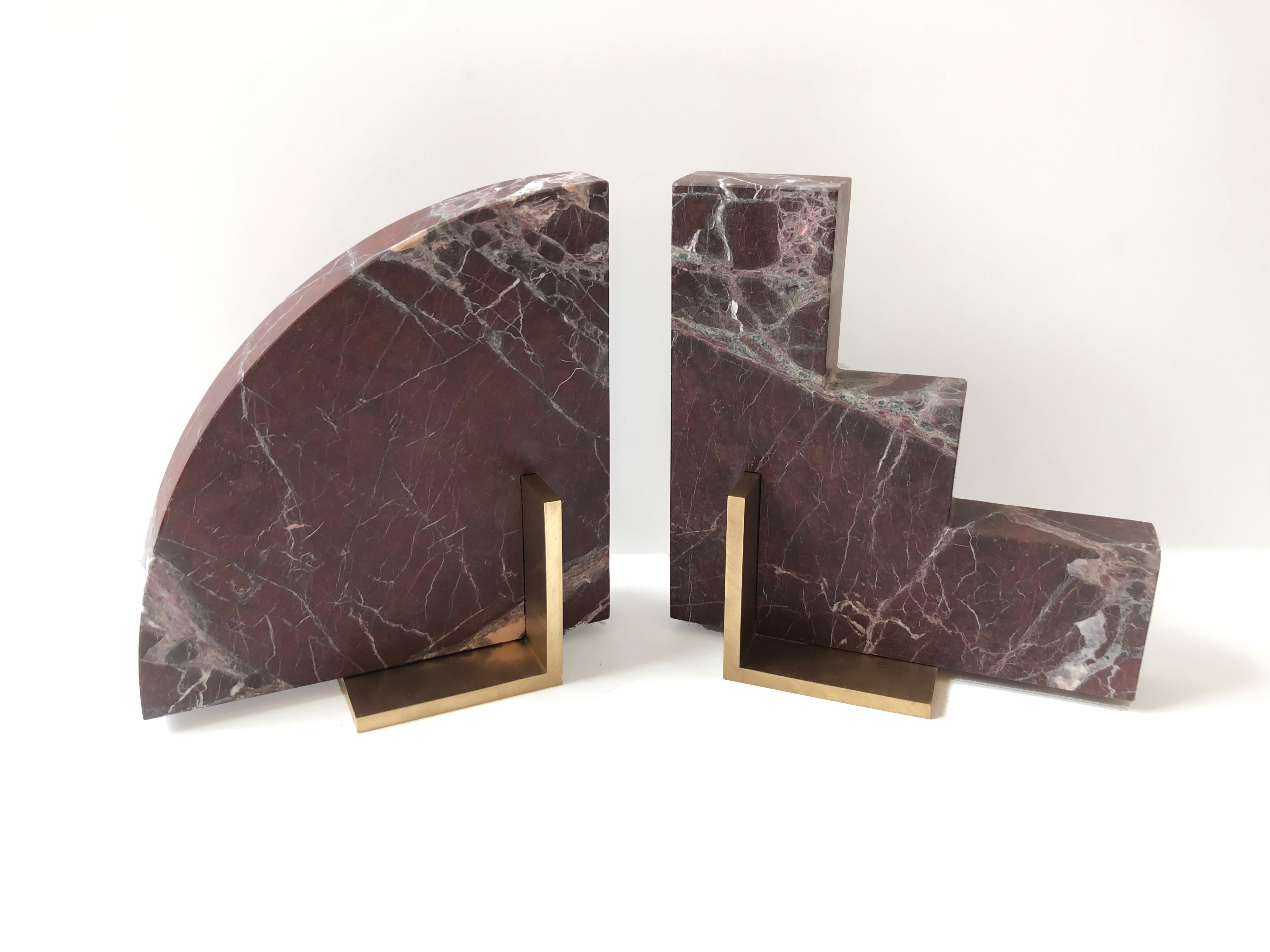 Meet Curvy and Steppy; the two individual bookends which as a pair are known as The Odd Couple Bookends.
Here shown in a honed Rosso Levanto marble with a brushed brass base.
The marble is cut into two geometric shapes and balanced over a brass