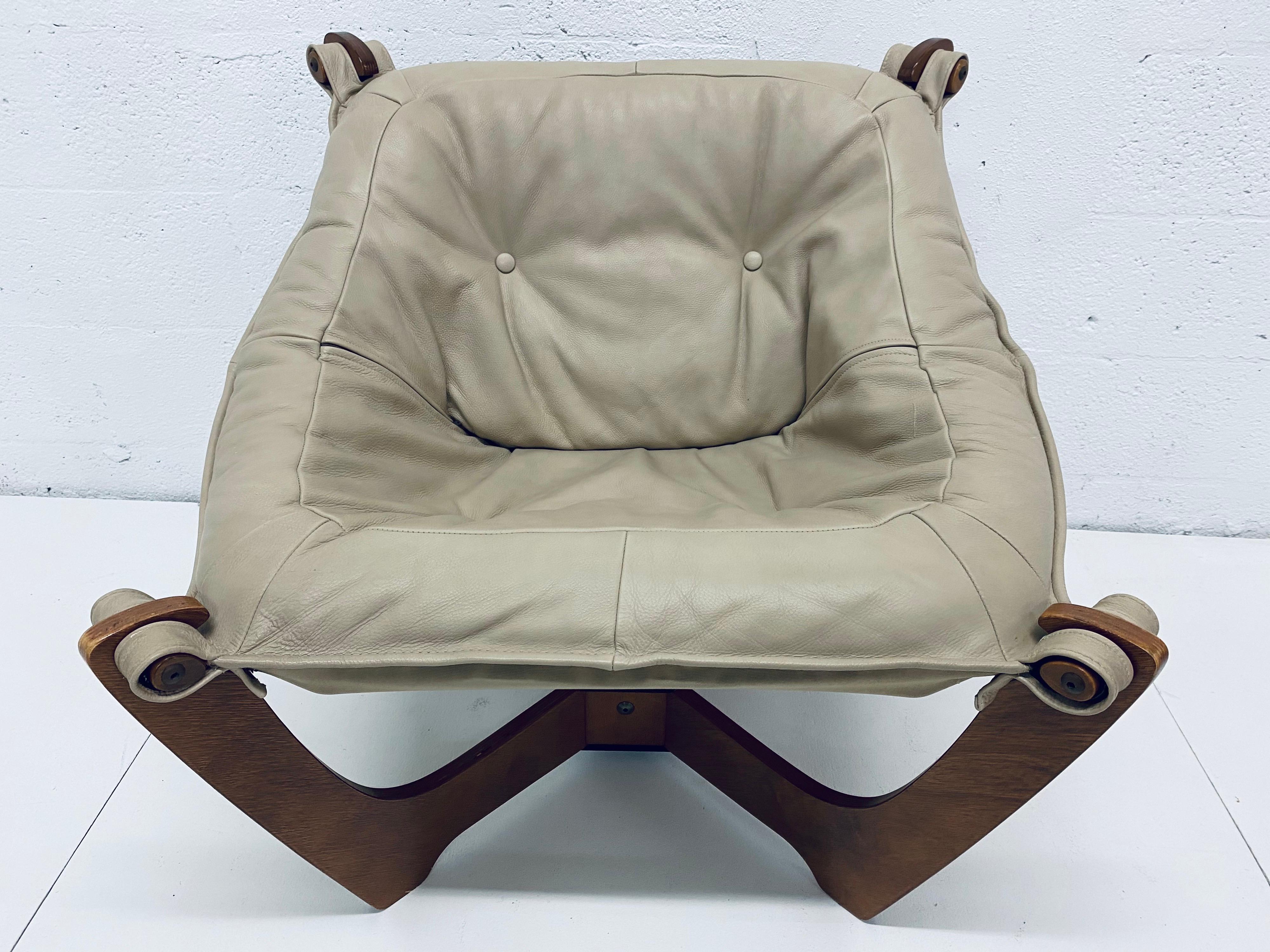Tan leather sling seat suspended from a dark stained wood frame by Odd Knutsen for Hjellegjerde.
