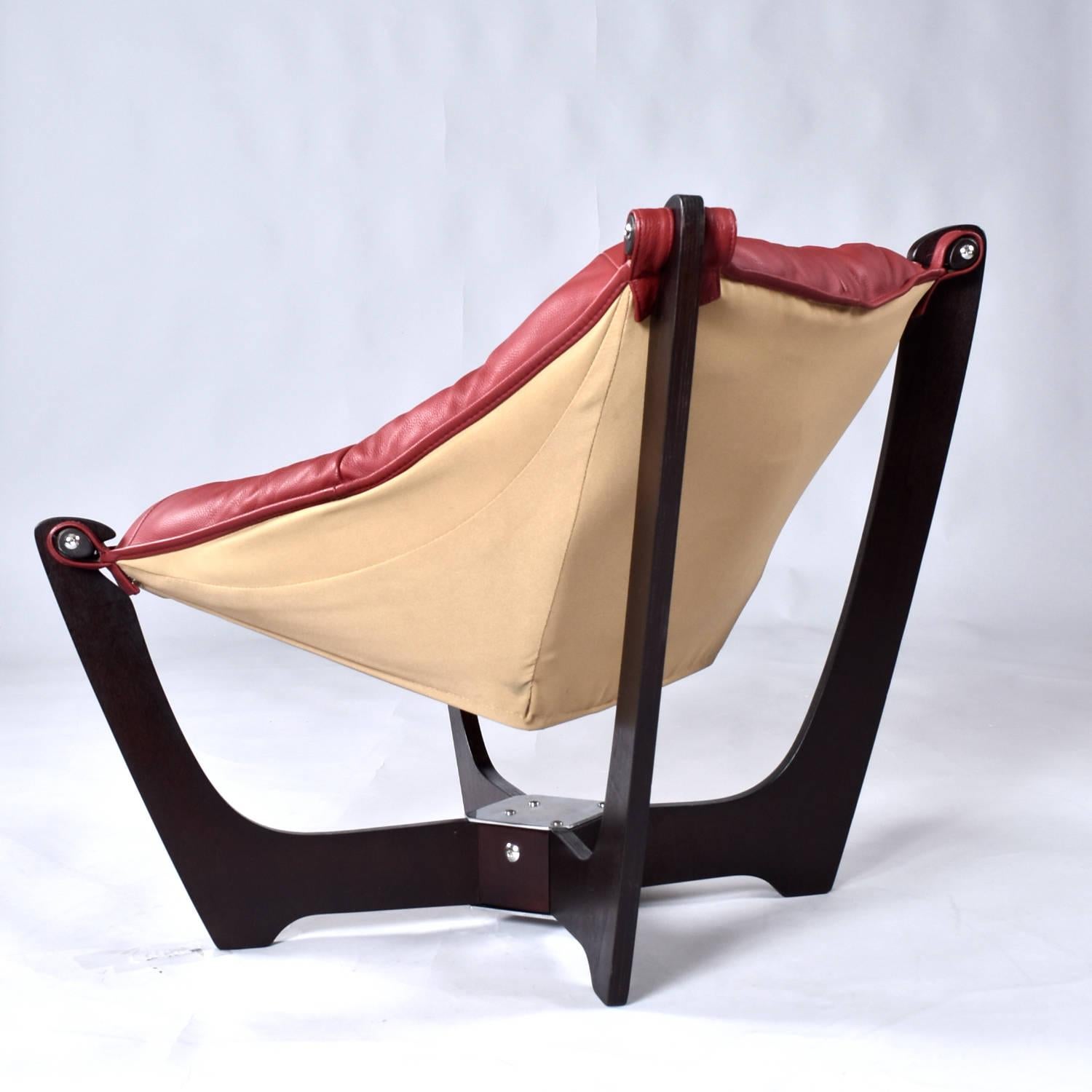 Ruby leather Luna sling chair by Norwegian designer, Odd Knutsen for International Mobel Group (IMG). The Luna chair first premiered in 1970 and has remained in production with Knutsen granting IMG license to produce. This chair is a newer