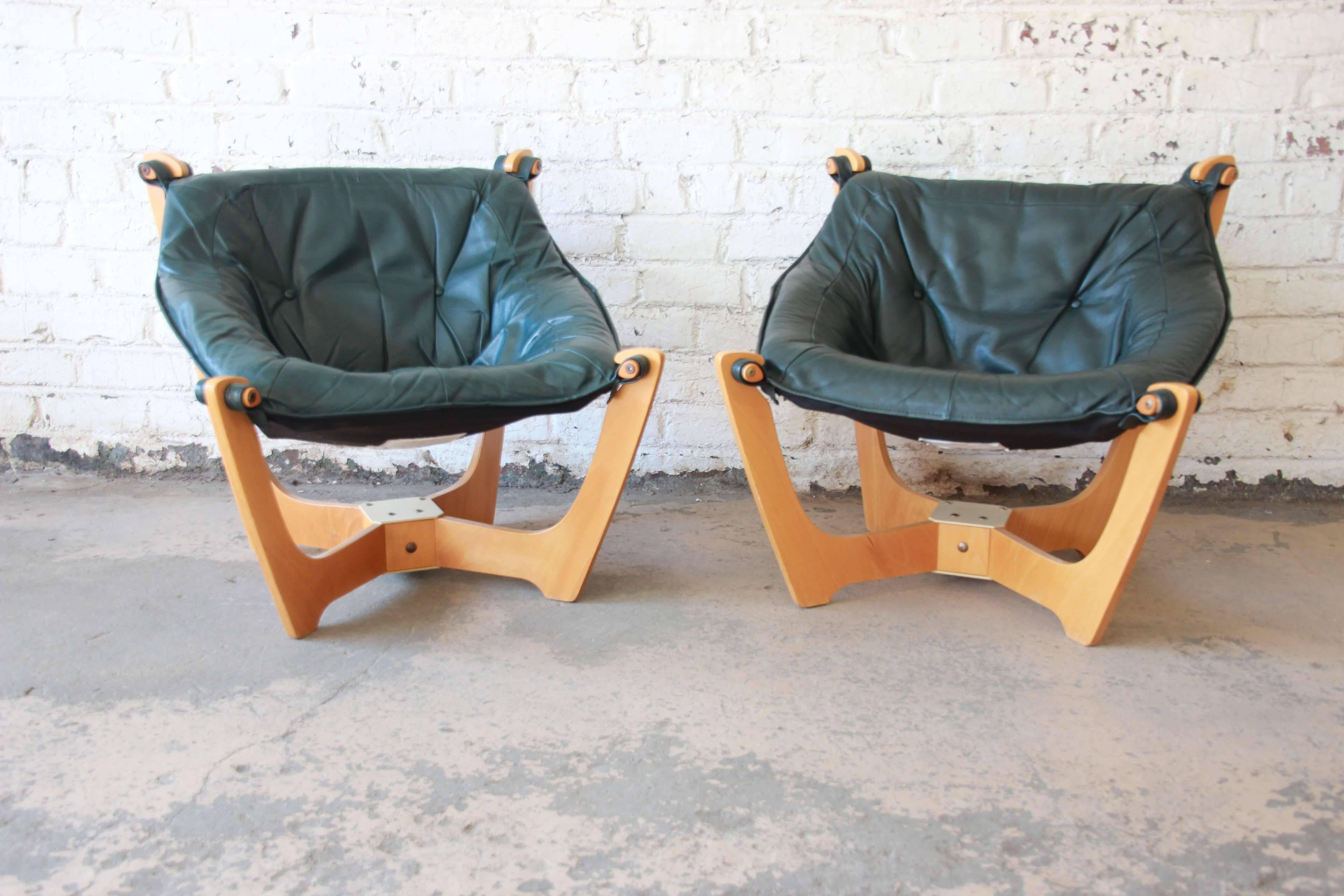 Offering a very nice pair of green leather 'Luna' chairs with teaks frames by Odd Knutsen. These extremely comfortable chairs sit of a four post teak frame with sturdy leather straps fastened to the frame. The leather is in good vintage condition