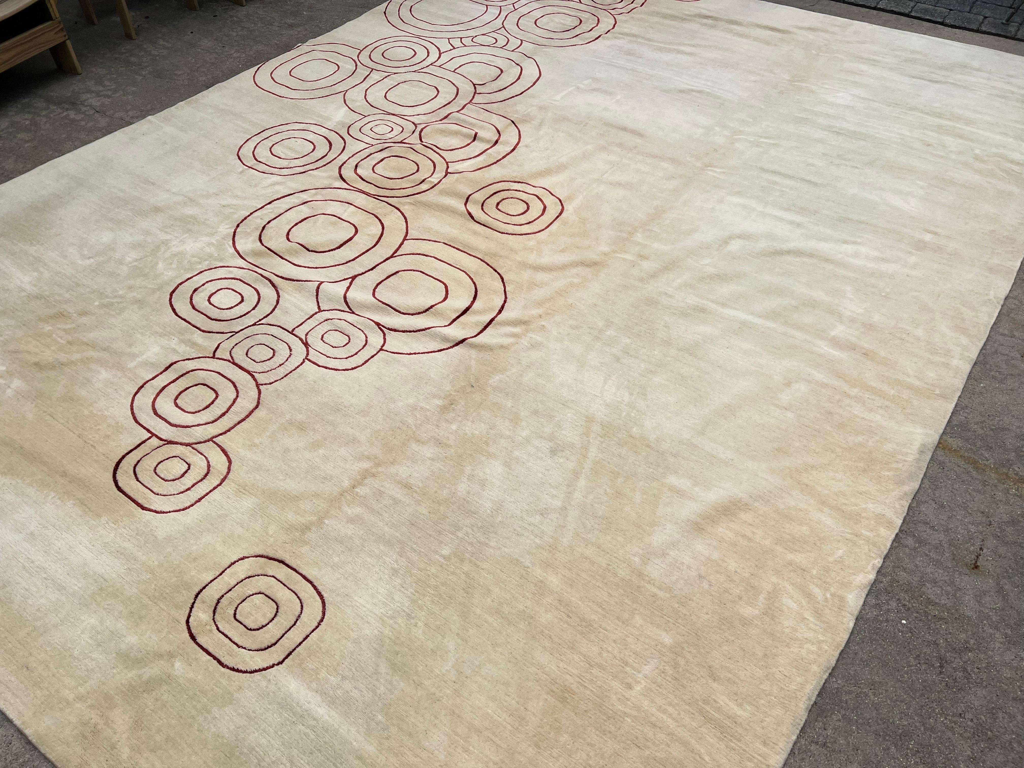 A large scale Odegard hand-knotted wool carpet with abstract design. Cream colored with dark red/burgundy decoration. 
