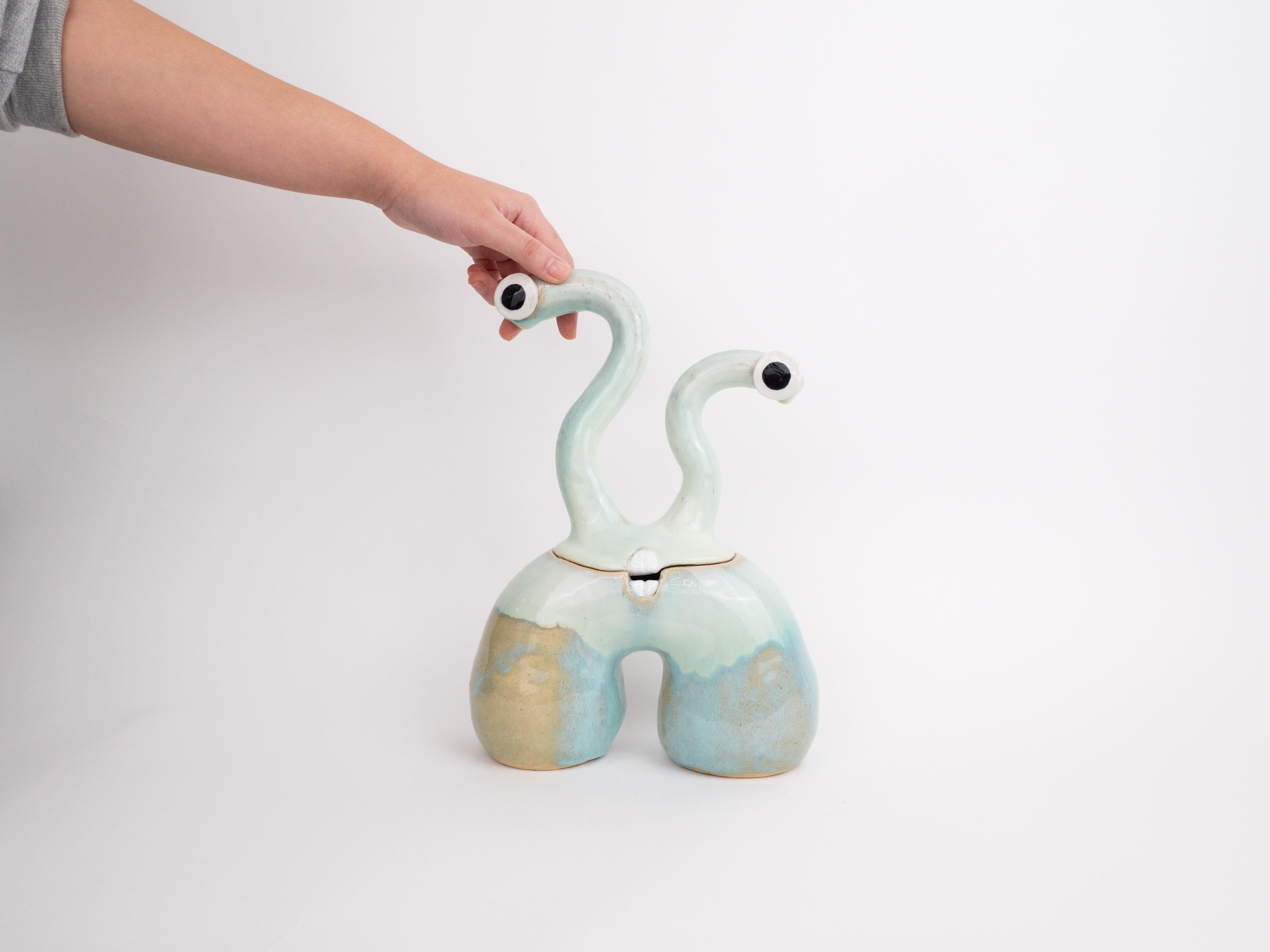 The Odele monster is a sculpture that doubles as a ceramic pot for all of your trinkets, sweets or goodies. Odele has a unique glaze applied to the body with hints of green, blue and purple, which gives the monster a cool and artistic feeling.