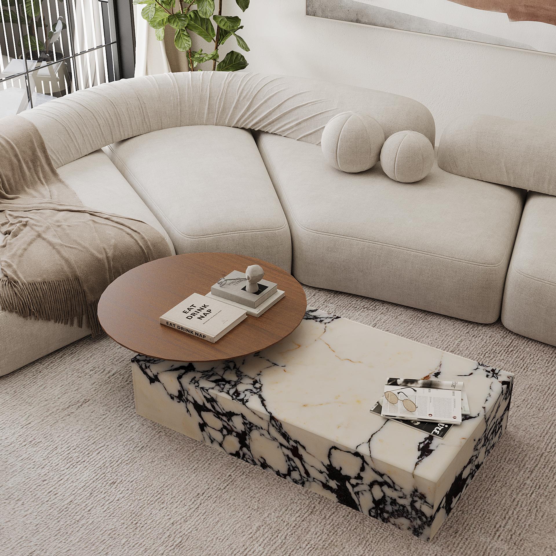 Une table basse moderne et élégante avec une base luxueuse en marbre et un plateau rond lisse et allongé. Naturelle pour ajouter une touche de sophistication à votre espace de vie, cette pièce combine le marbre naturel avec le bois résultant en un