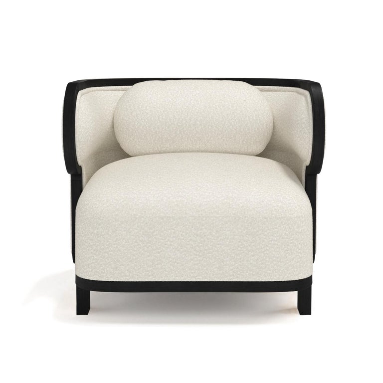 The Odette club chair is a modern take on the cozy wingback armchair that defies all categorizations, being also describable as a Bergère, as well as a barrel chair, thanks to its wooden frame and curved back. Upholstered with brushed Casentino