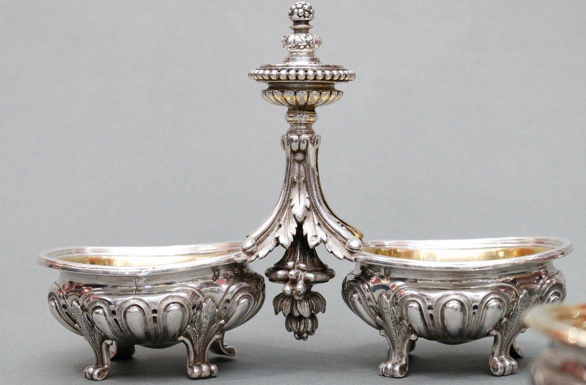 Paire de salières doubles en argent massif, intérieur de la coupe en vermeil amovible, modèle à grands godrons sur fond amati, chacune montée sur quatre pieds à feuilles d'acanthe. Reliés par une tige centrale formée de feuilles d'acanthe, retenus