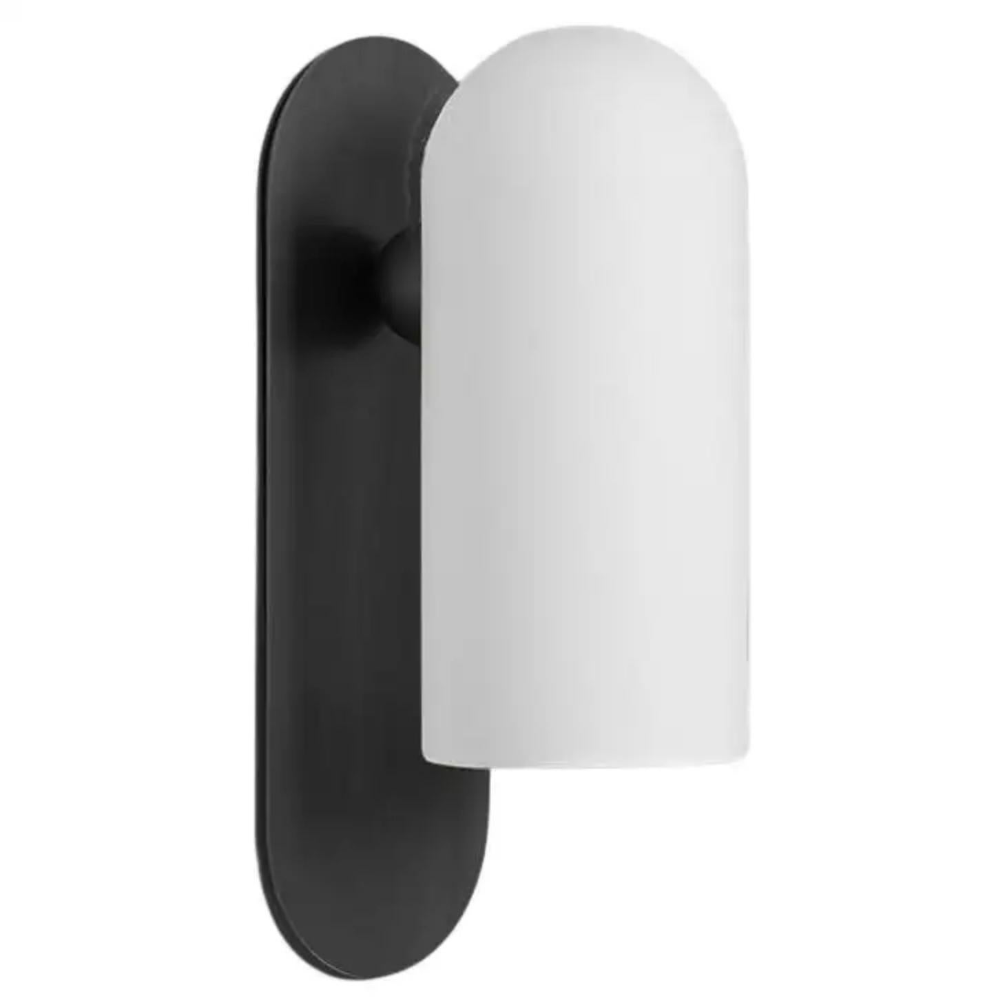 Black medium sconce by Schwung.
Dimensions: W 10.5 x D 14 x H 30.5 cm.
Materials: Black gunmetal, frosted glass.

Finishes available: Black gunmetal, polished nickel, brass.


Schwung is a German word, and loosely defined, means energy or momentumm