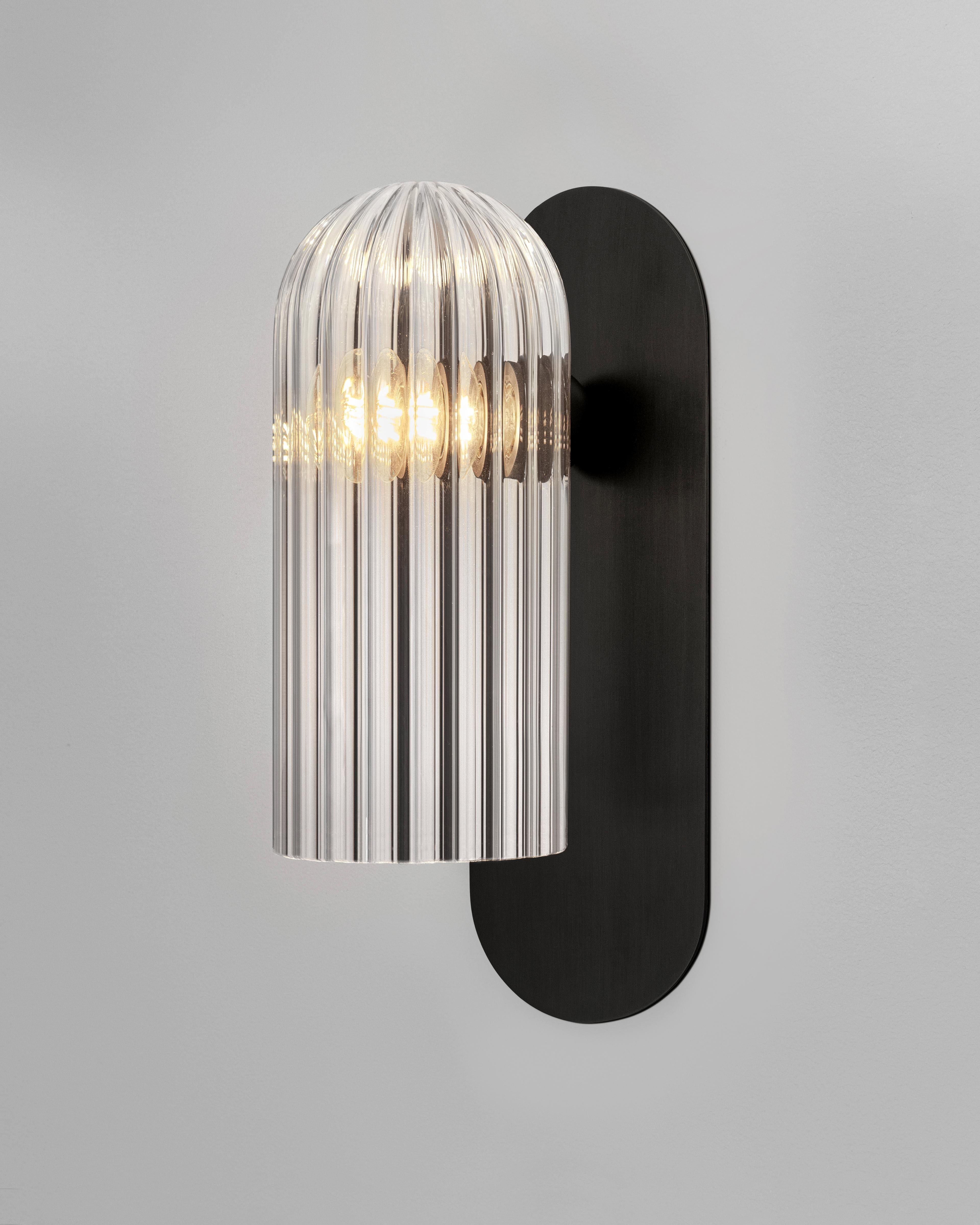 Odyssey Paris Wall Sconce by Schwung.
Dimensions: W 10.5 x D 14.4 x H 30.5 cm.
Materials: Black gunmetal, glass.

Available in black gunmetal, polished nickel, lacquered burnished brass.

Schwung is a German word, and loosely defined, means energy