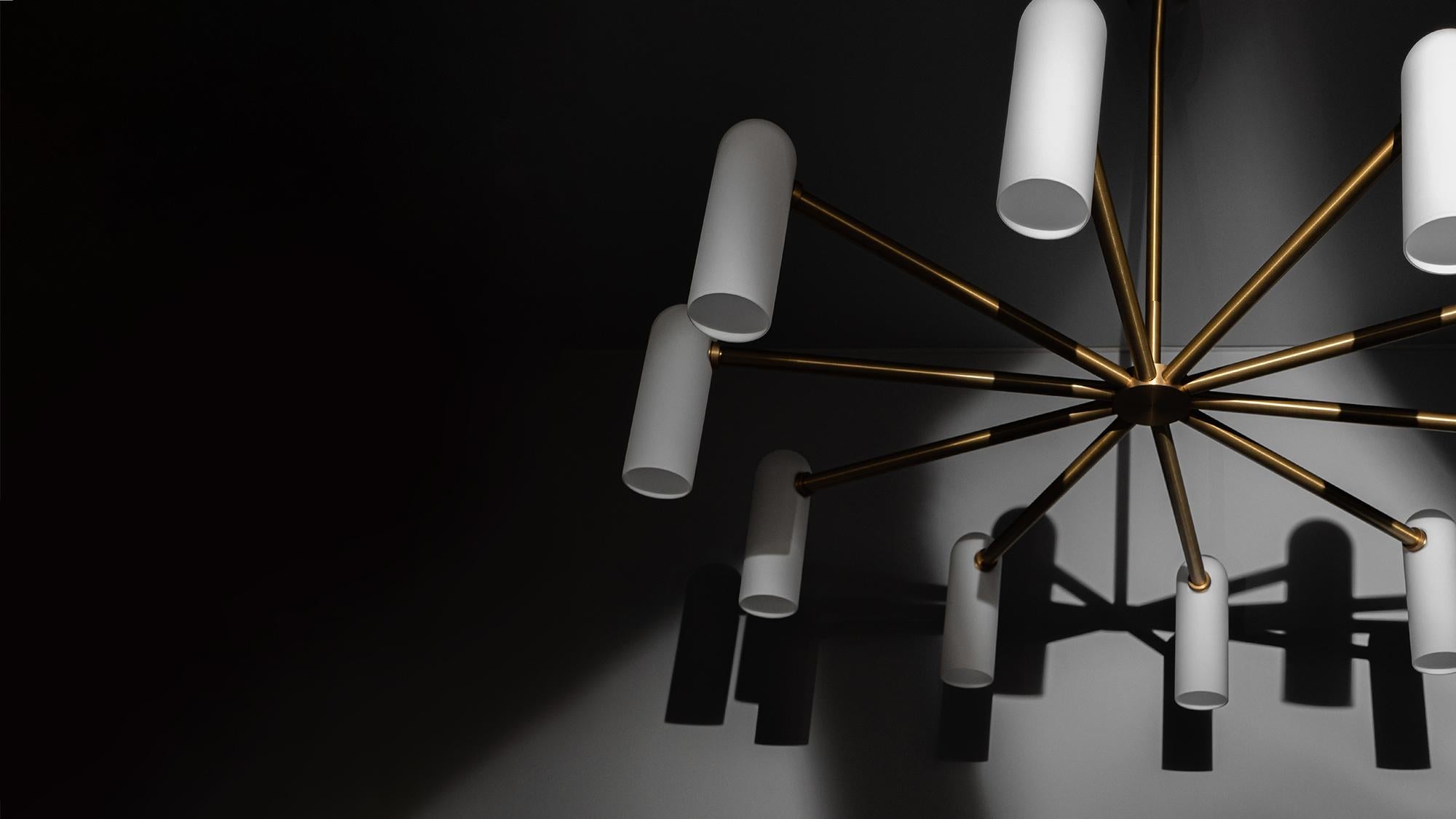Spokes of brass hold slender lampshades, the circle of light creating a planetary effect in this striking round chandelier. Arched shapes drape downward while emanating an atmospheric twinkle.

Available in our three signature finishes: Lacquered