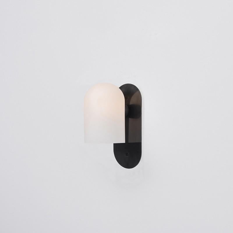 Odyssey SM Black Wall Sconce by Schwung
Dimensions: W 10.5 x D 14 x H 23 cm
Materials: Black gunmetal, frosted glass

Finishes available: Black gunmetal, polished nickel, brass
Other sizes available.

Schwung is a German word, and loosely defined,
